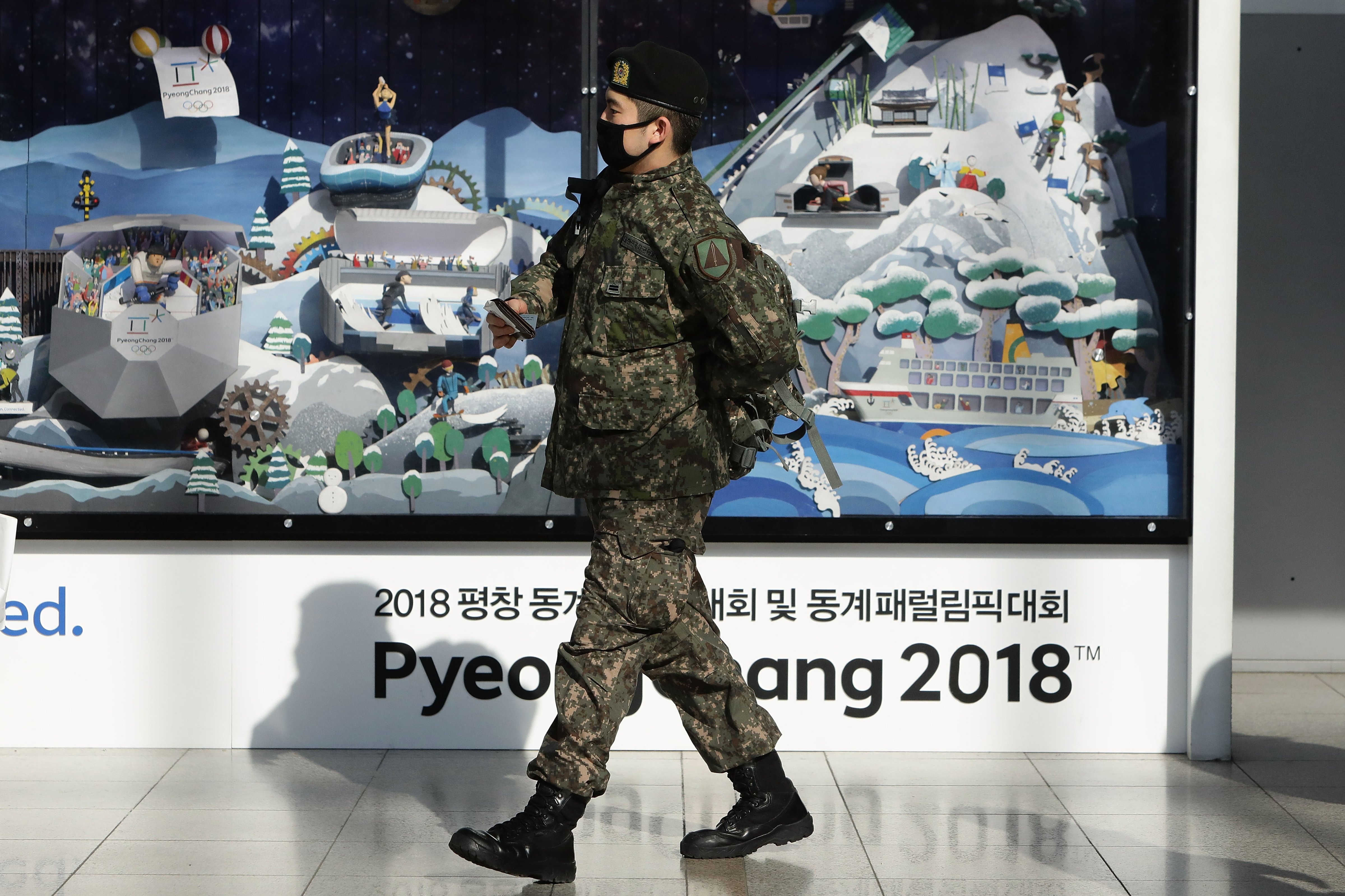 A South Korean soldier walks past the 2018 Pyeongchang Winter Olympic and Paralympic Games PR booth in Seoul, South Korea on Jan. 5, 2018. (Chung Sung-Jun—Getty Images)