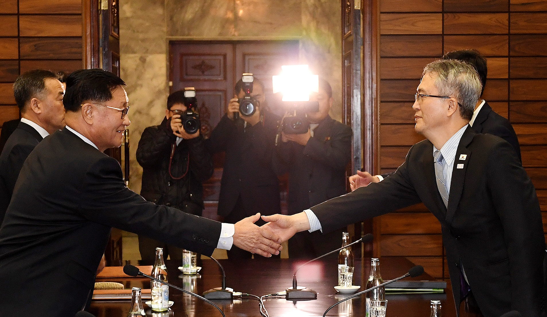 Kwon Hyok Bong, director general of the art-performance management bureau at North Korea's culture ministry, and Lee Woo-sung, a senior official at South Korea's Ministry of Culture, Sports and Tourism, shake hands during a meeting at the Tongil Gak building in the village of Panmunjom in the Demilitarized Zone in North Korea, on Jan. 15, 2018. (KPPA/Pool/Bloomberg/Getty Images)