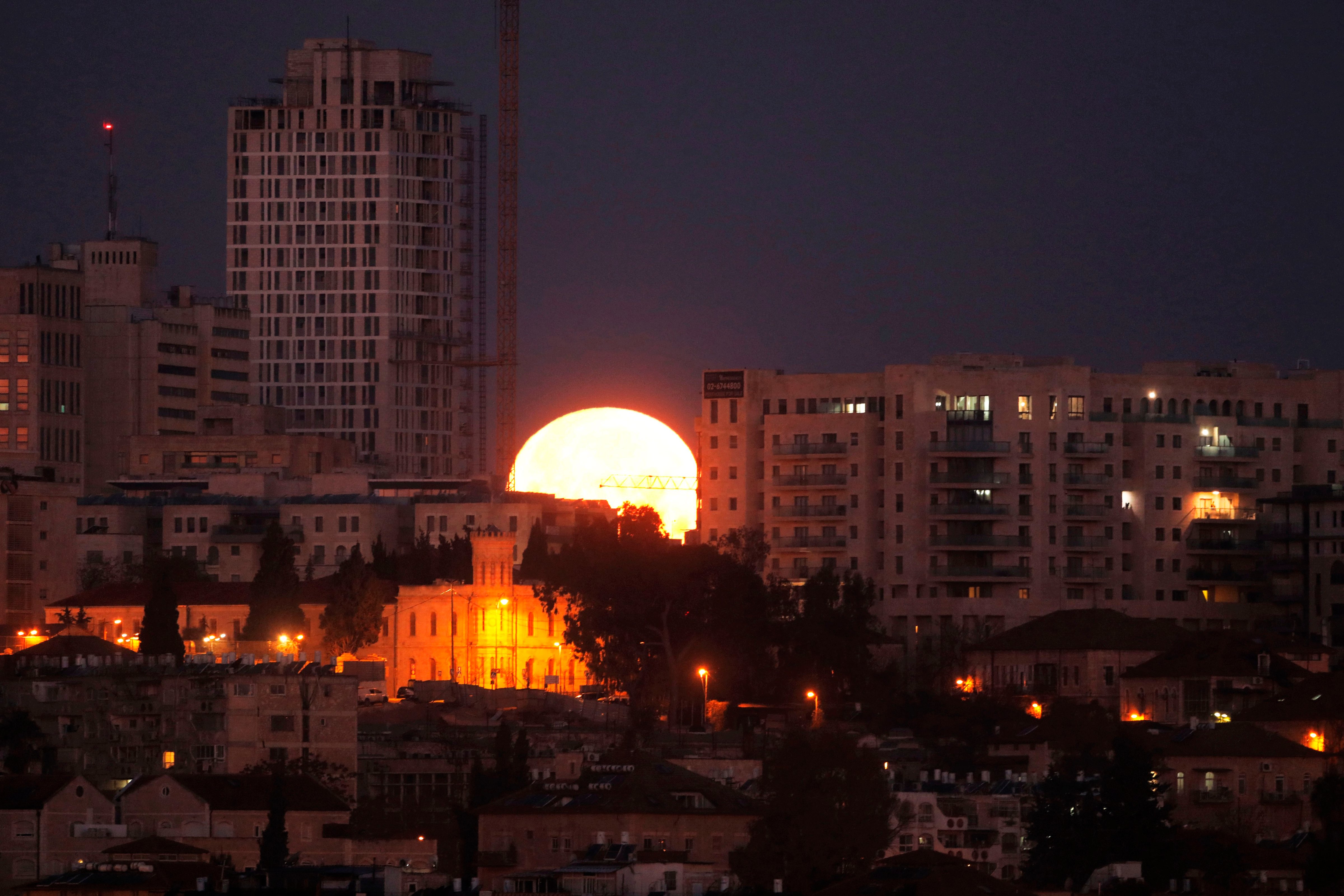 The moon sets behind the city of Jerusalem early on Jan. 31, 2018. (Menahem Kahana—AFP/Getty Images)