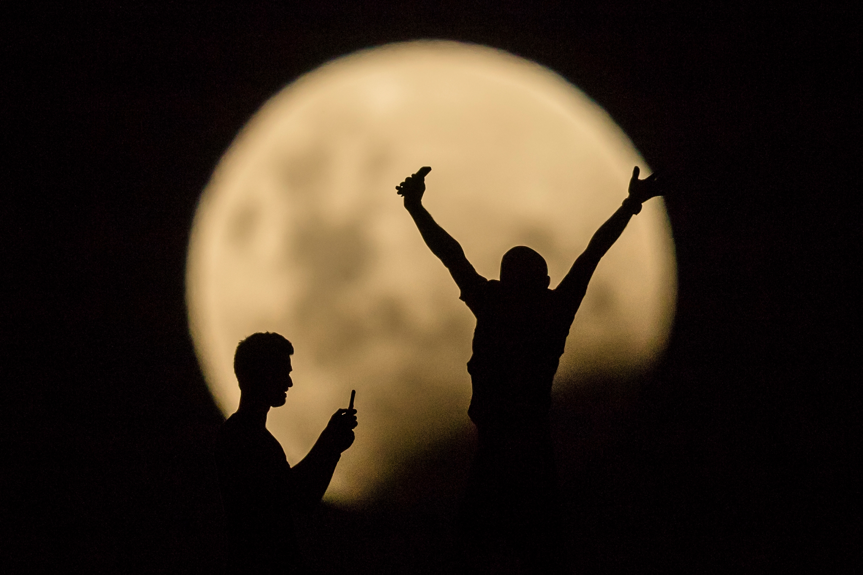 People take photos of the Super moon in Lancelin, Australia, on Jan. 31, 2018. (Paul Kane—Getty Images)
