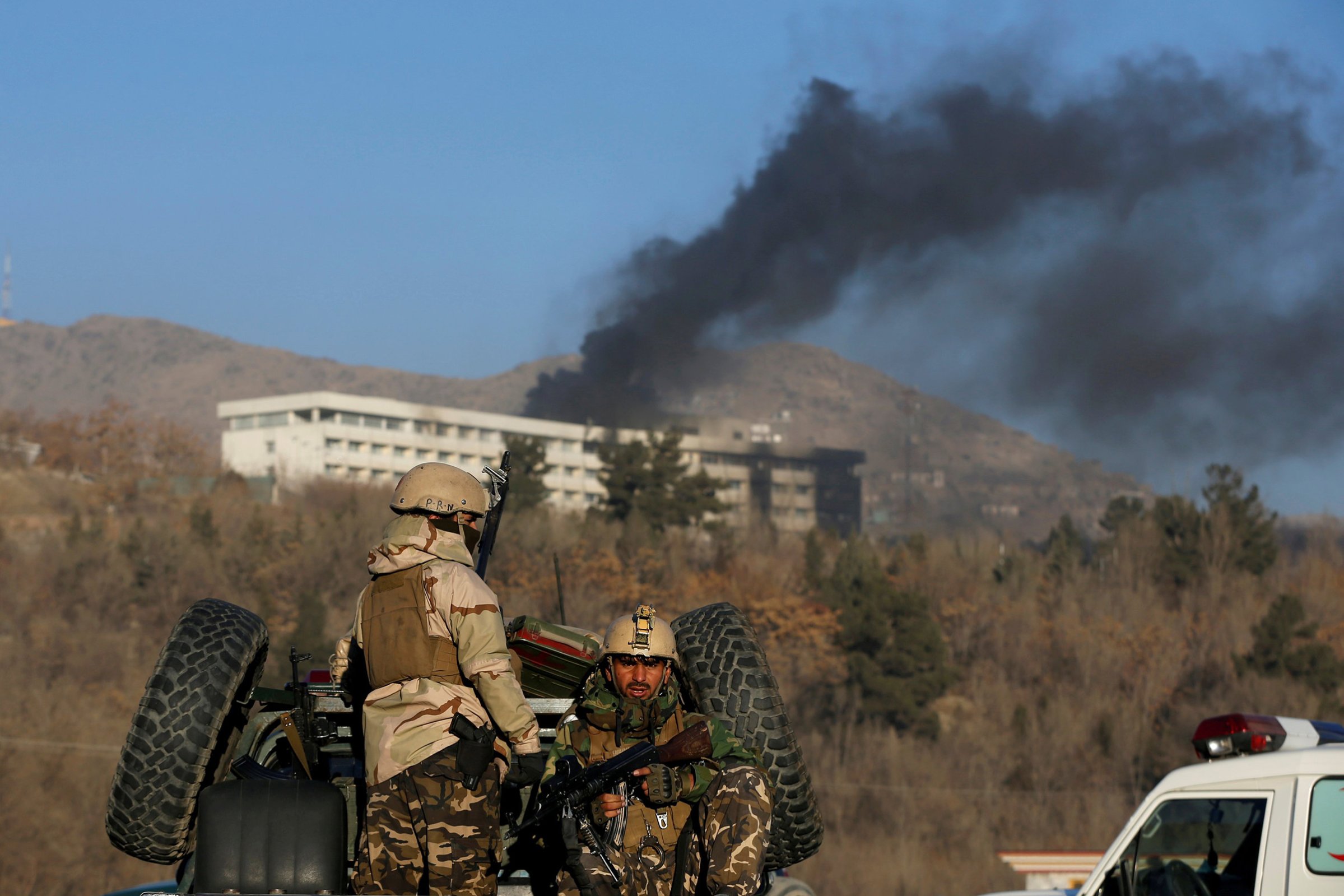 Afghan security forces keep watch as smoke rises from the Intercontinental Hotel in Kabul, Afghanistan