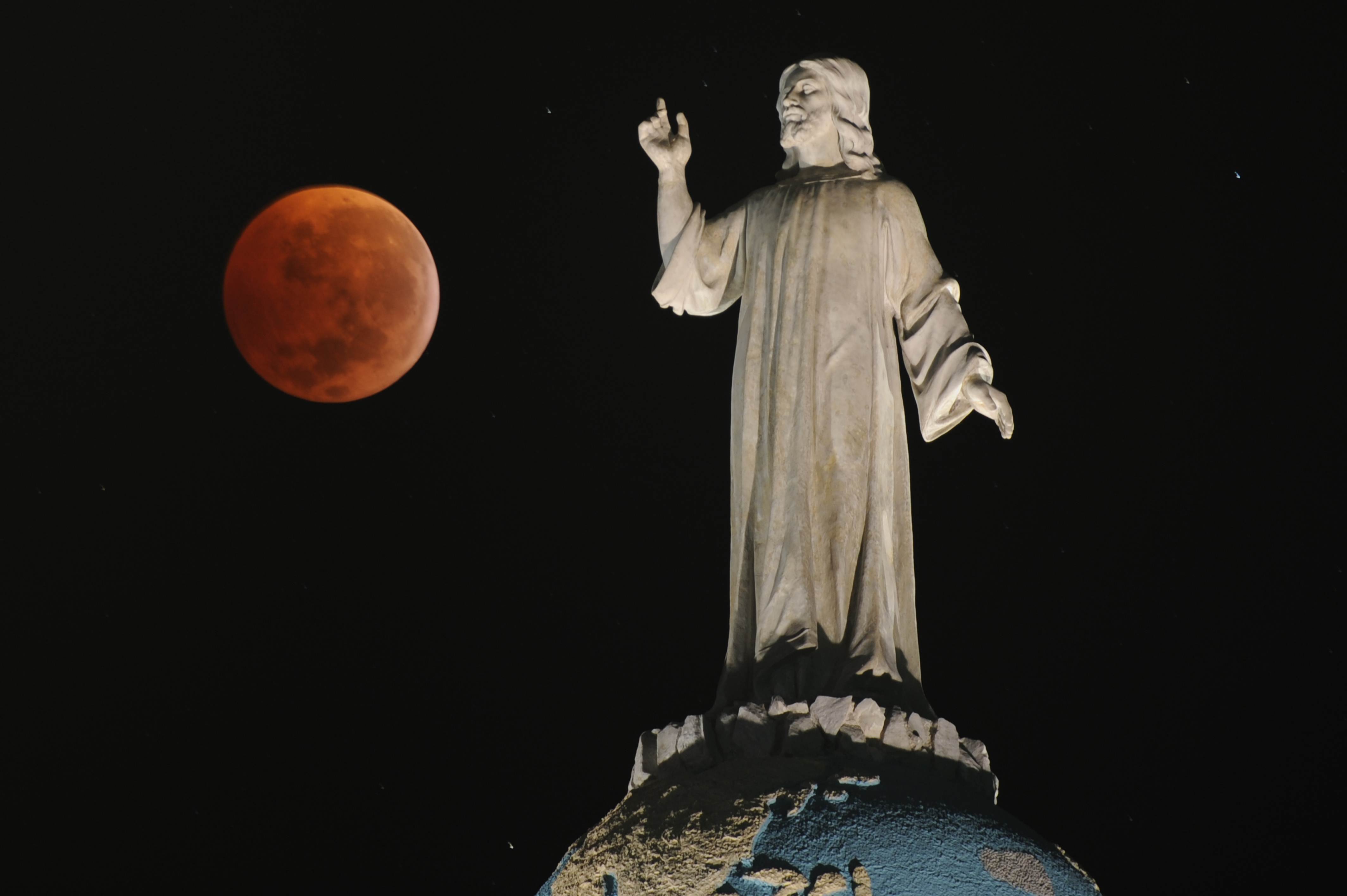 A double exposure picture shows the moon and the monument of The Savior of The World during a total lunar eclipse as seen from San Salvador, El Salvador on December 21, 2010. (Jose Cabezas—AFP/Getty Images)