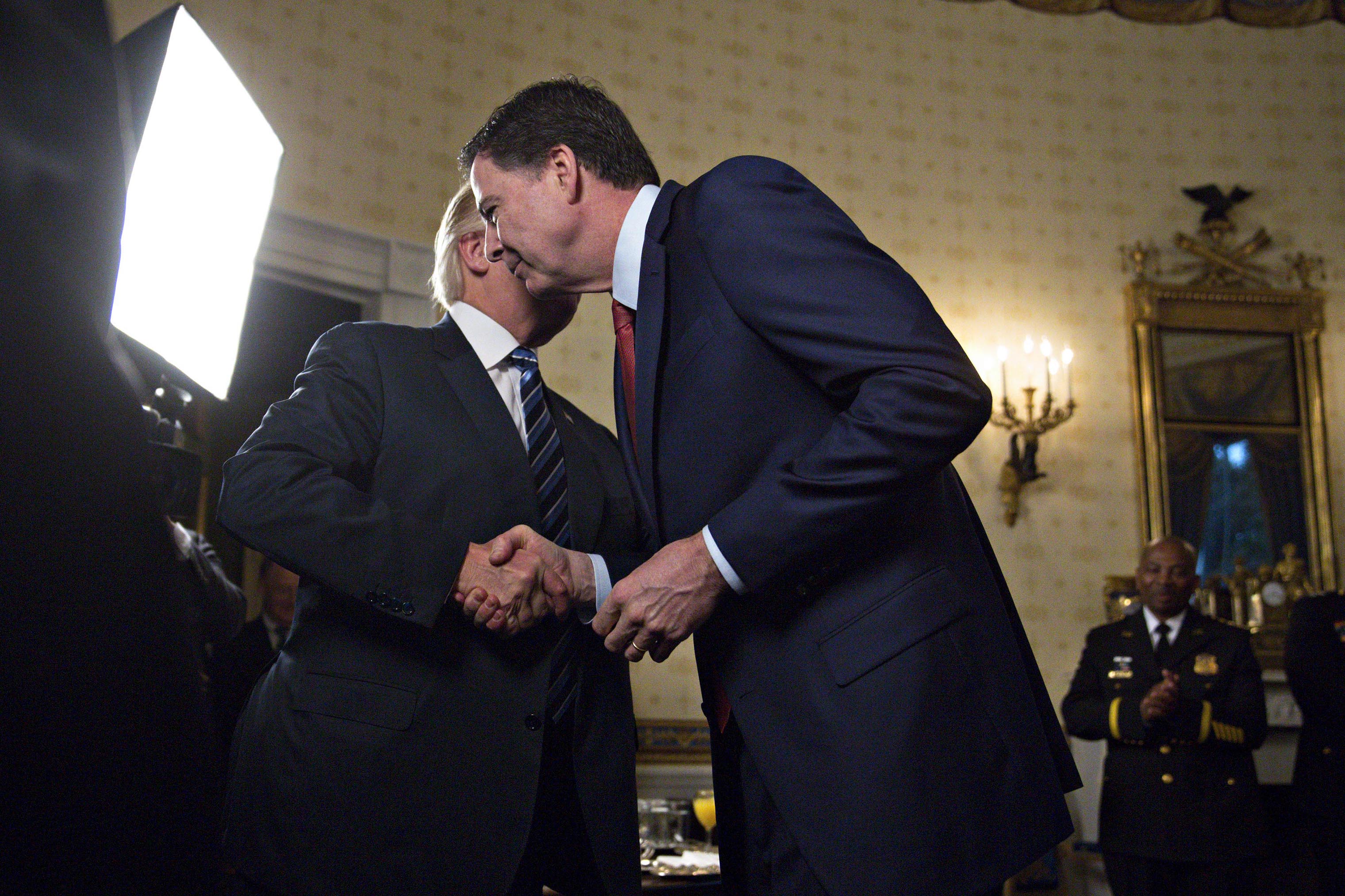President Donald Trump shakes hands with James Comey, director of the FBI, during an Inaugural Law Enforcement Officers and First Responders Reception in the Blue Room of the White House on Jan. 22, 2017. (Andrew Harrer—Bloomberg)