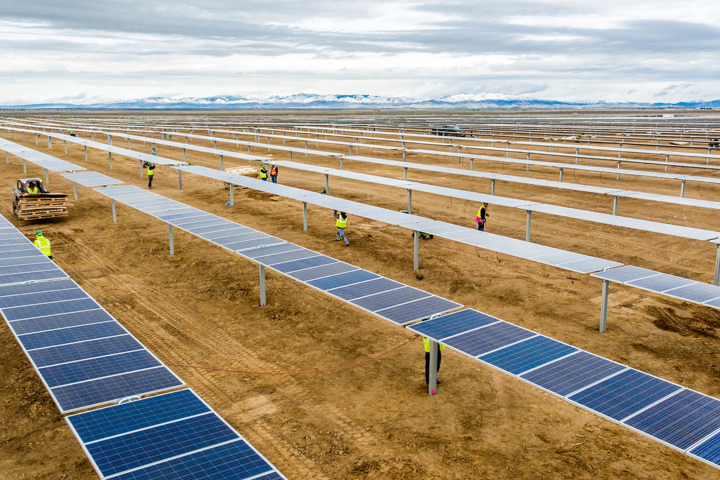 Construction crews assemble solar modules for a 55-megawatt power plant in Idaho built by DEPCOM