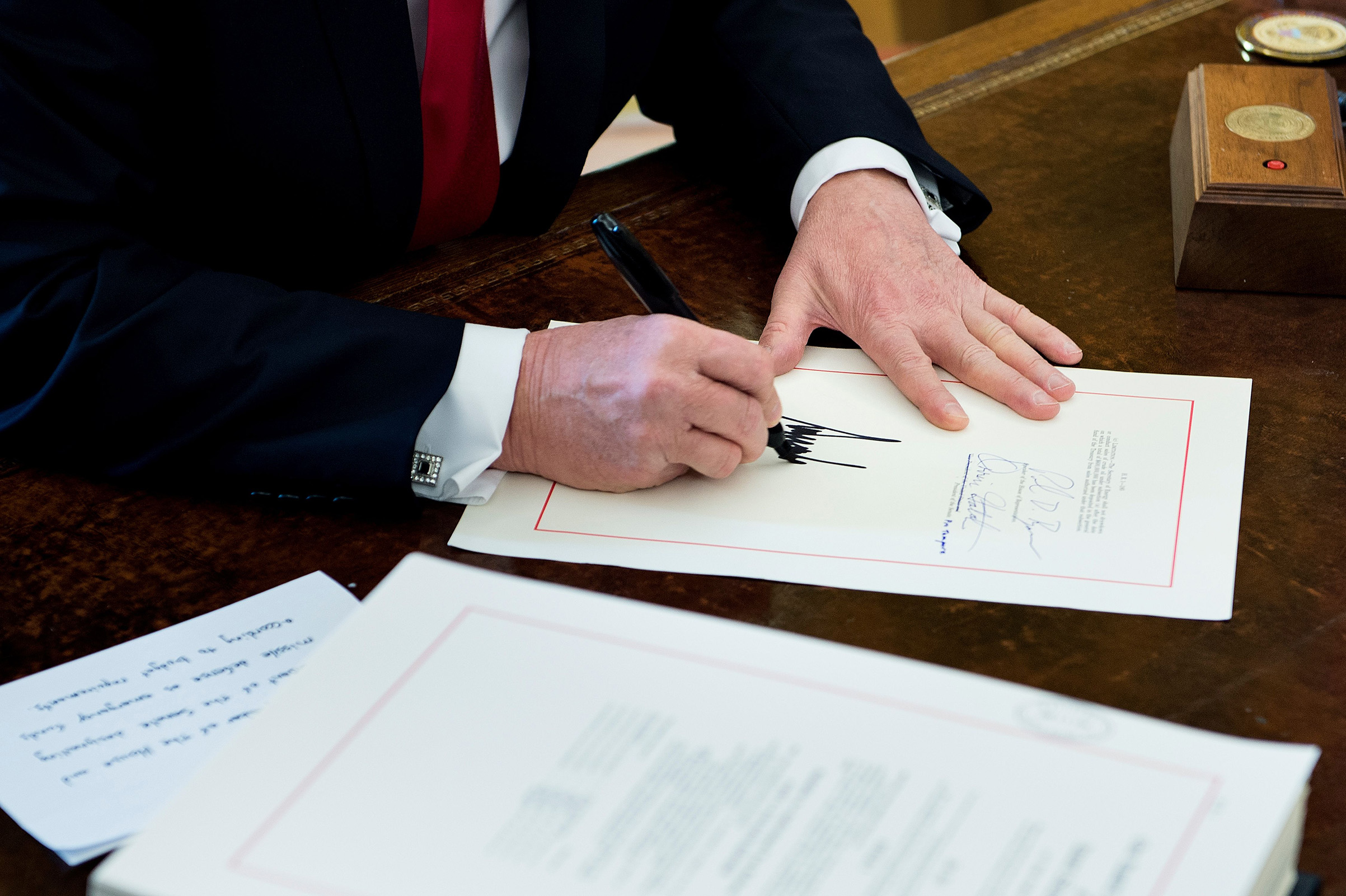 President Donald Trump signs the Tax Cut and Reform Bill in the Oval Office at The White House on Dec. 22, 2017. (Brendan Smialowski—AFP/Getty Images)
