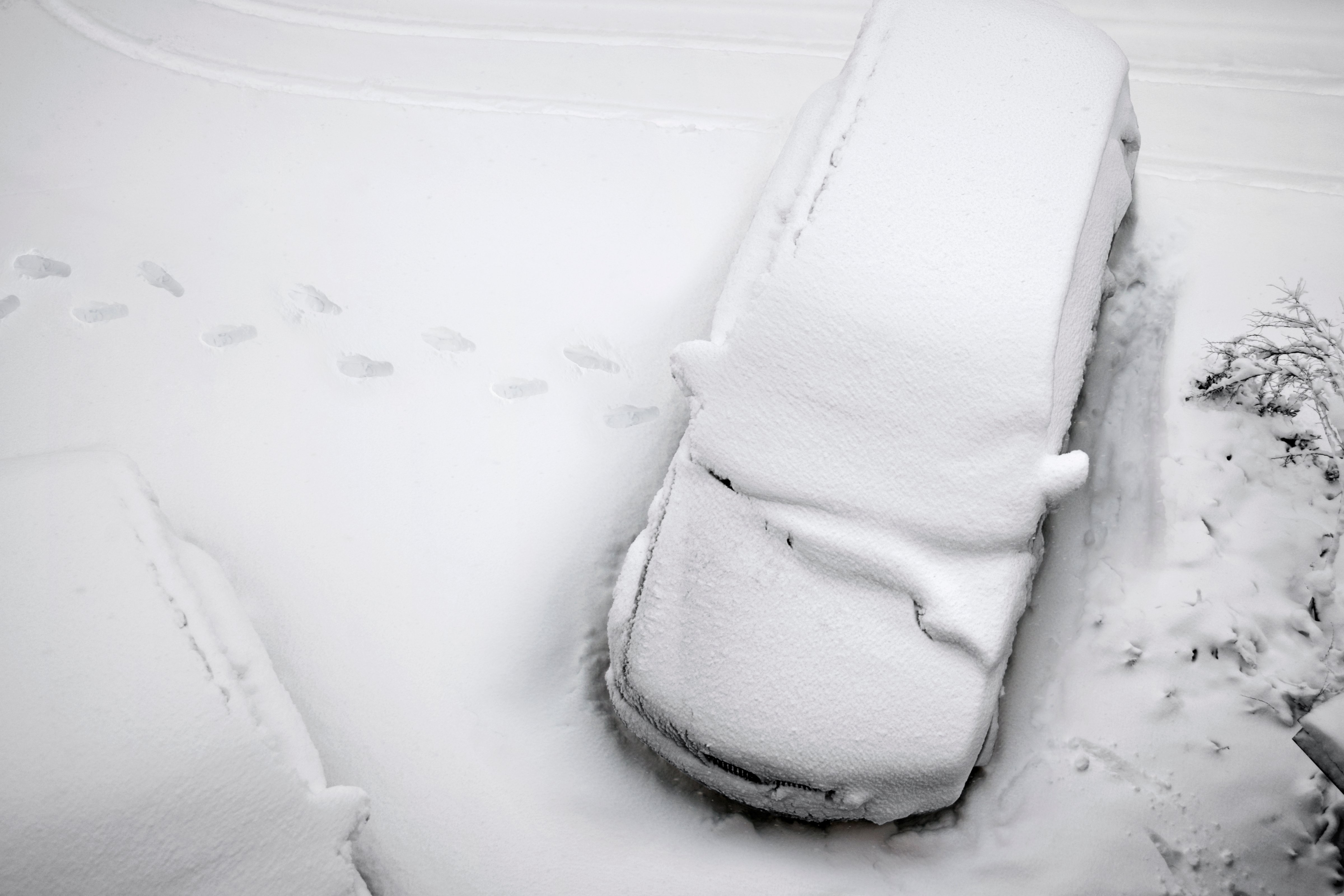 A car abandoned in the snow with foot prints leading away from the abandoned vehicle. (Hype Photography—Getty Images)