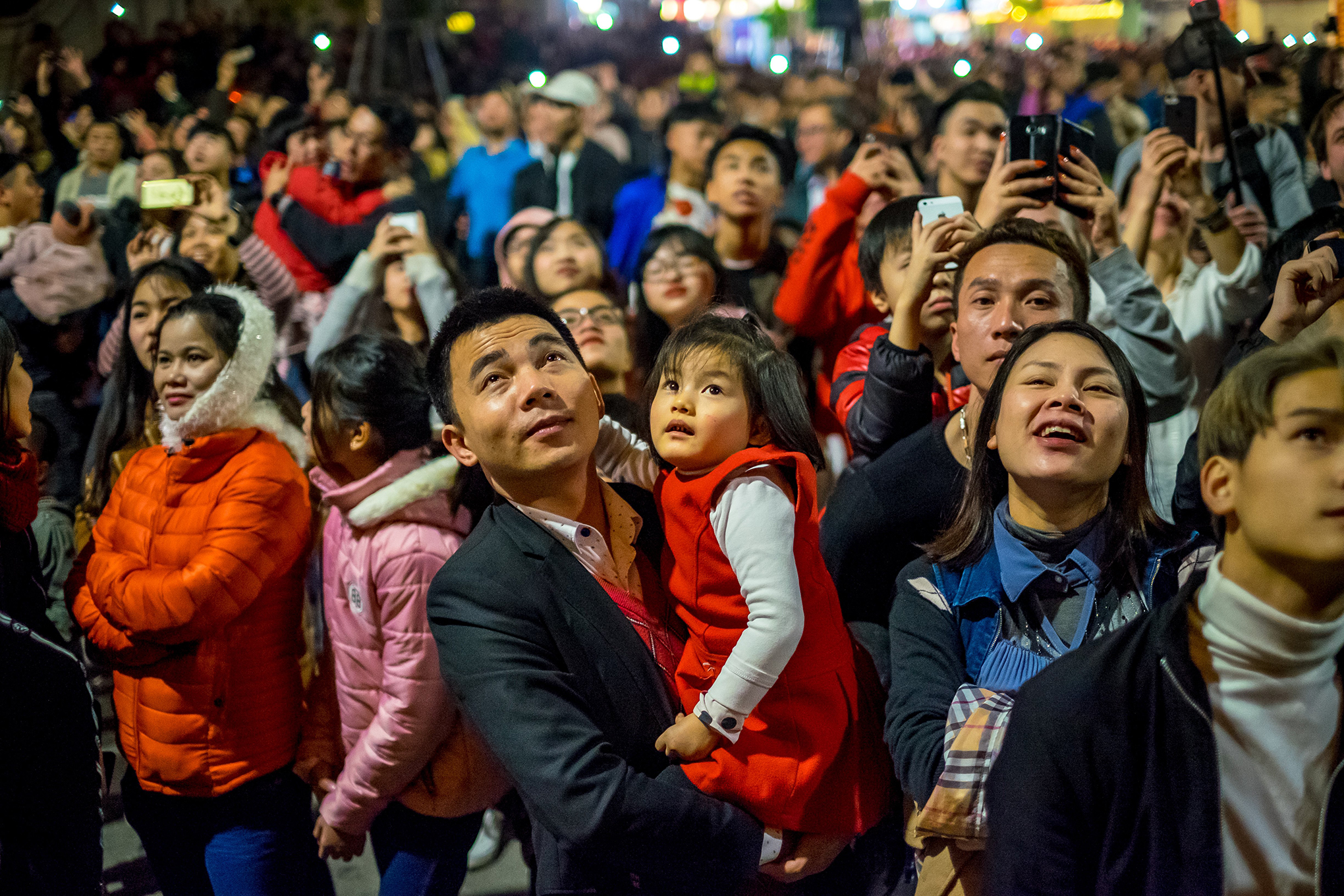 People watch a firework display to mark the Lunar New Year celebrations of the Year of the Dog at the Old Quarter on Feb. 16, 2018 in Hanoi, Vietnam.