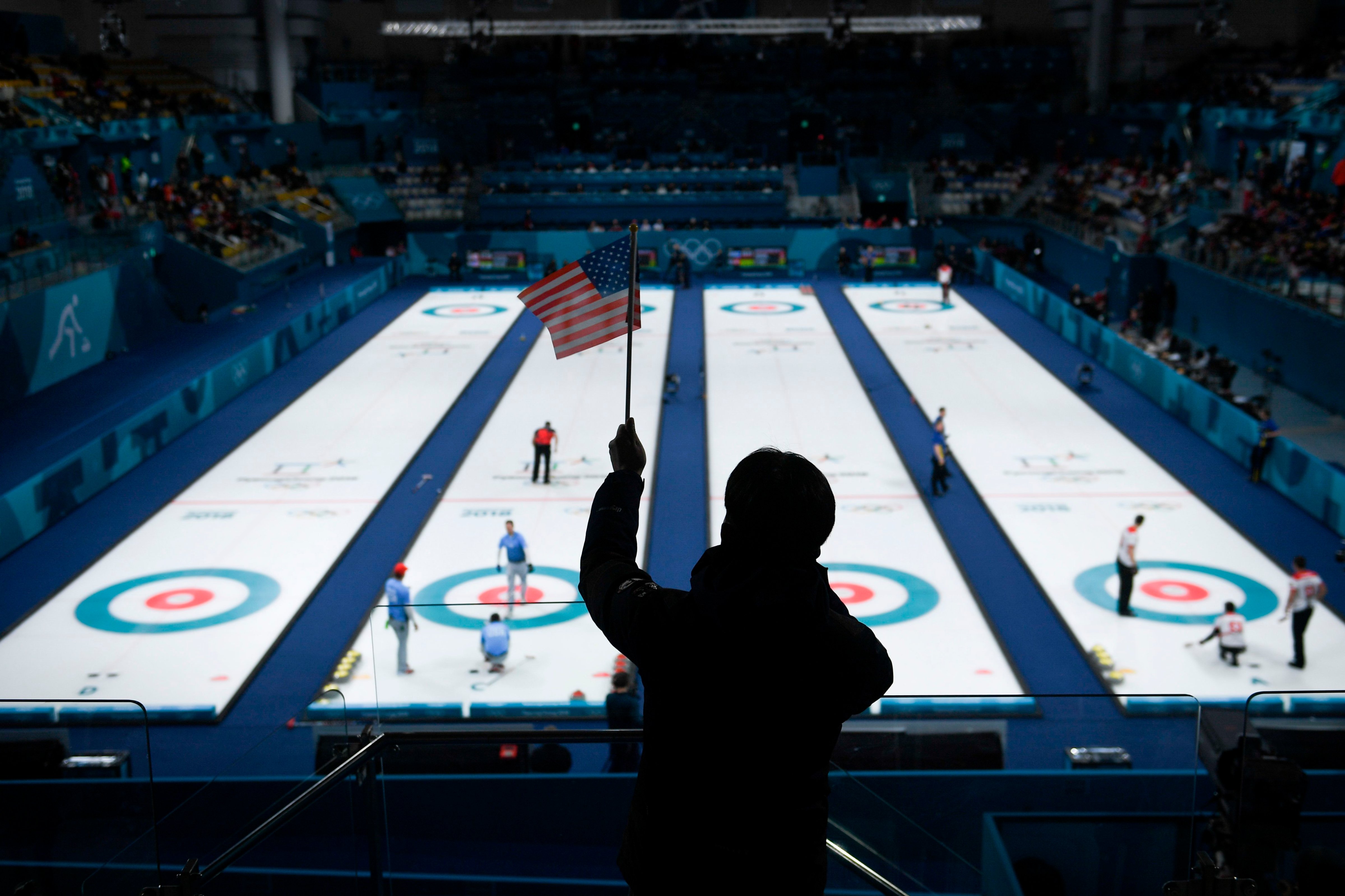 A man waves an American flag during the curling men's semi-final game between Canada and USA during the Pyeongchang 2018 Winter Olympic Games at the Gangneung Curling Centre in Gangneung on February 22, 2018. (WANG ZHAO—AFP/Getty Images)