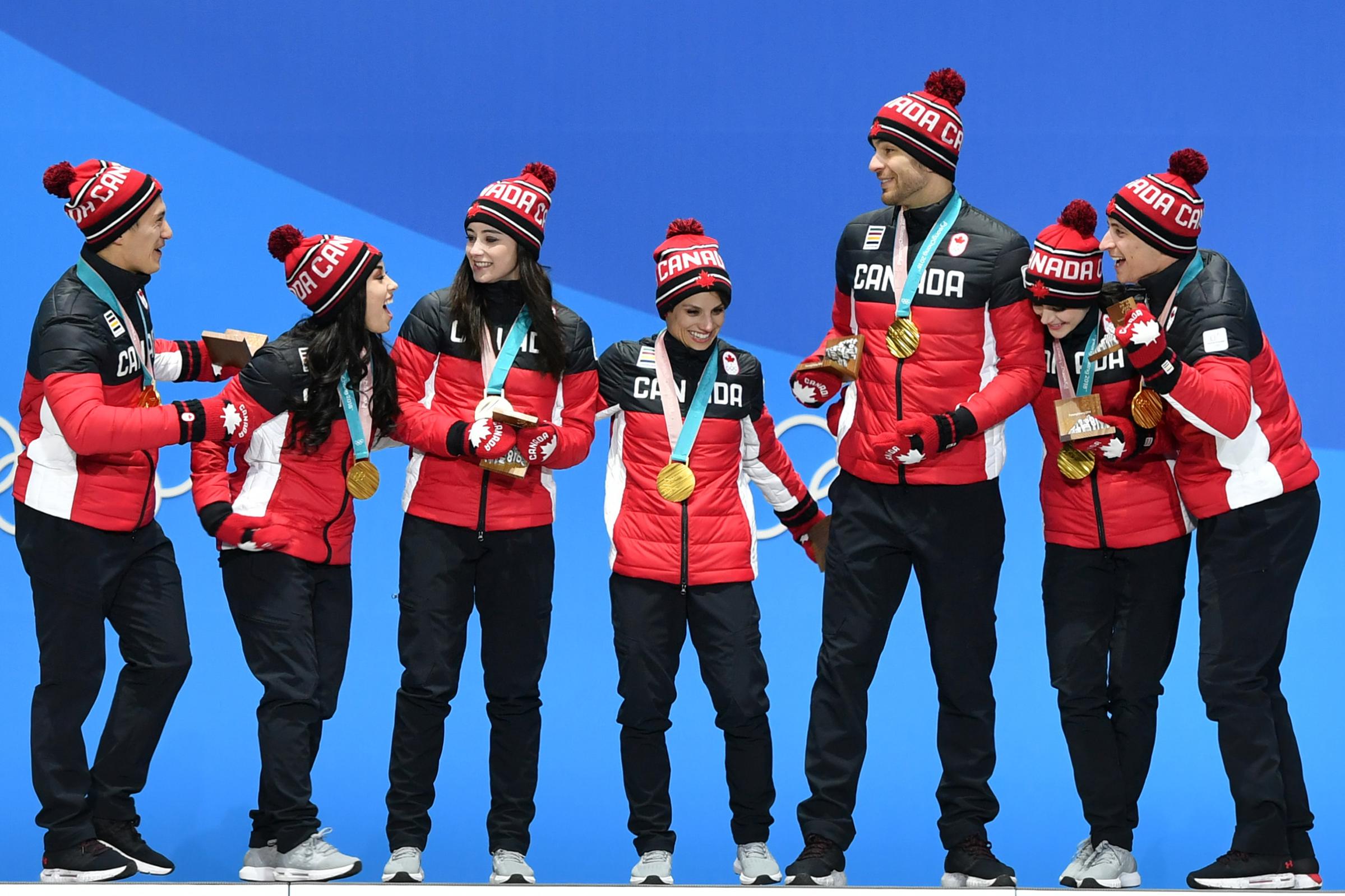 Canada's gold medal-winning team celebrate on the podium during the medal ceremony for the figure skating team event on Feb. 12, 2018.