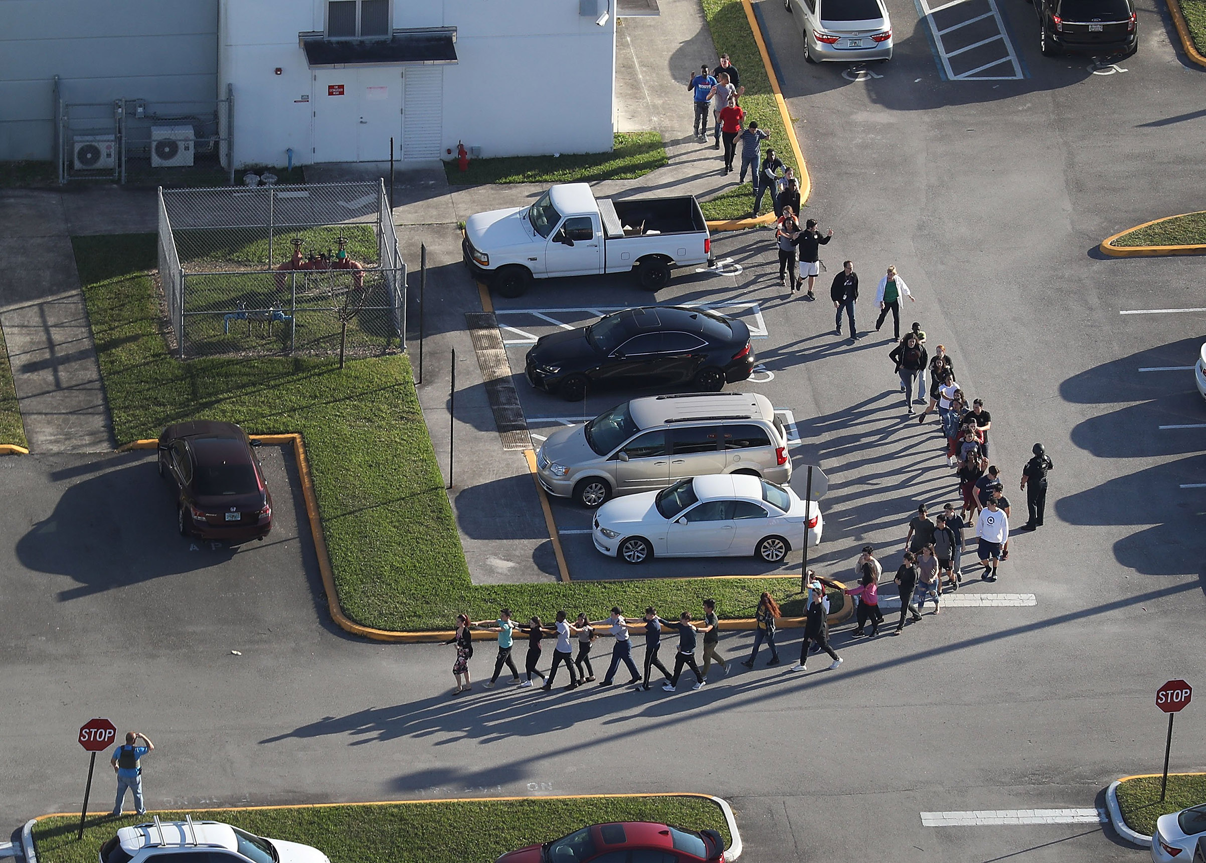 Students are evacuated from Marjory Stoneman Douglas High School in Parkland, Fla., on Feb. 14, after a shooting left at least 17 people dead. (Joe Raedle—Getty Images)