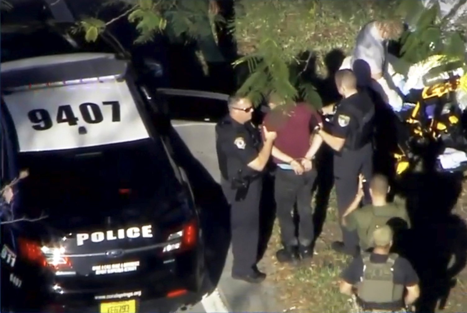 A man placed in handcuffs is led by police near Marjory Stoneman Douglas High School following a shooting incident in Parkland, Fla. Feb. 14, 2018 in a still image from video. (WSVN.com/Reuters)