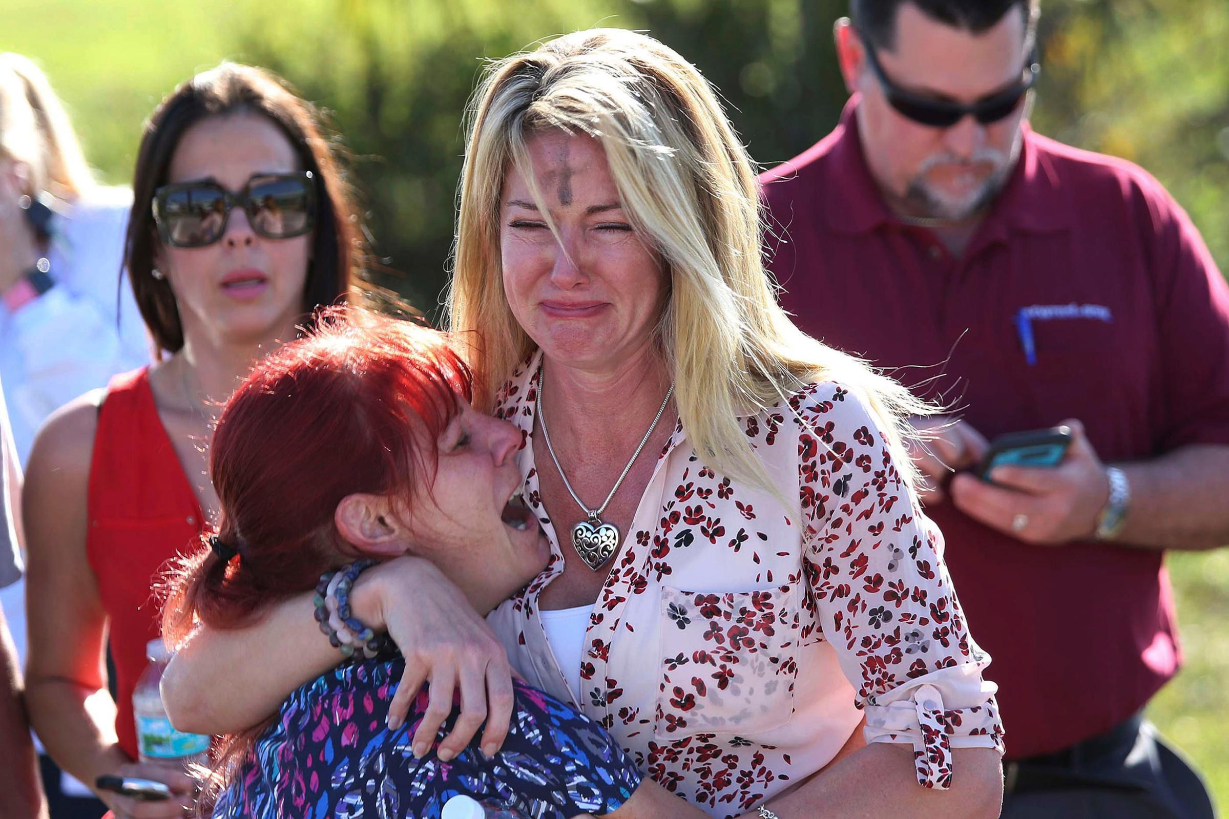Parents wait for news after a reports of a shooting at Marjory Stoneman Douglas High School in Parkland, Fla., on Feb. 14, 2018.