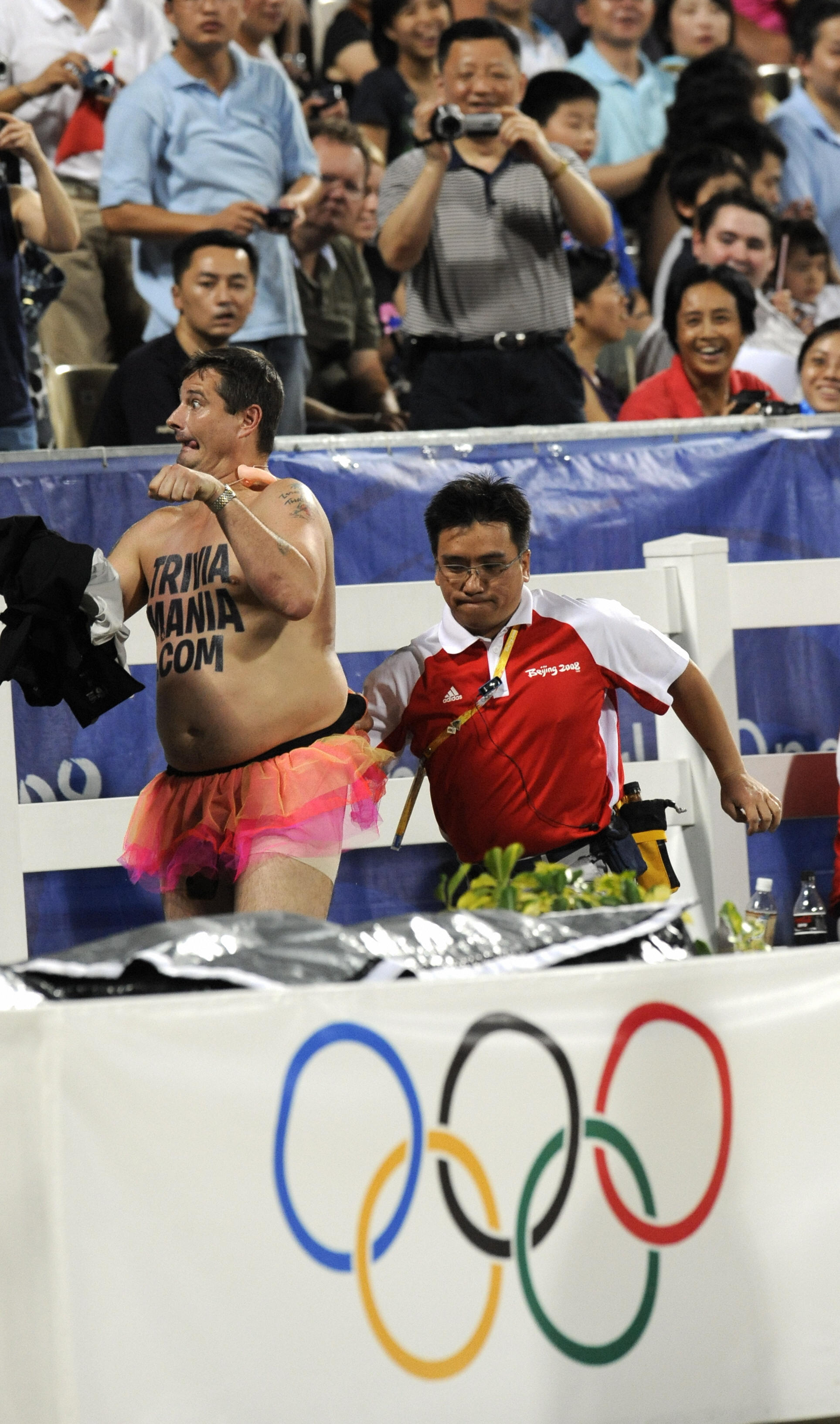 An Official escorts British streaker Mark Roberts after he "performed" during the jumping individual final of the 2008 Beijing Olympic Games on August 21, 2008 in Hong Kong . Ten riders jumped clear rounds in the first of two qualifying rounds of the Olympic individual show jumping final here Thursday. AFP PHOTO/DDP/DAVID HECKER (Photo credit should read DAVID HECKER/AFP/Getty Images) (AFP—AFP/Getty Images)