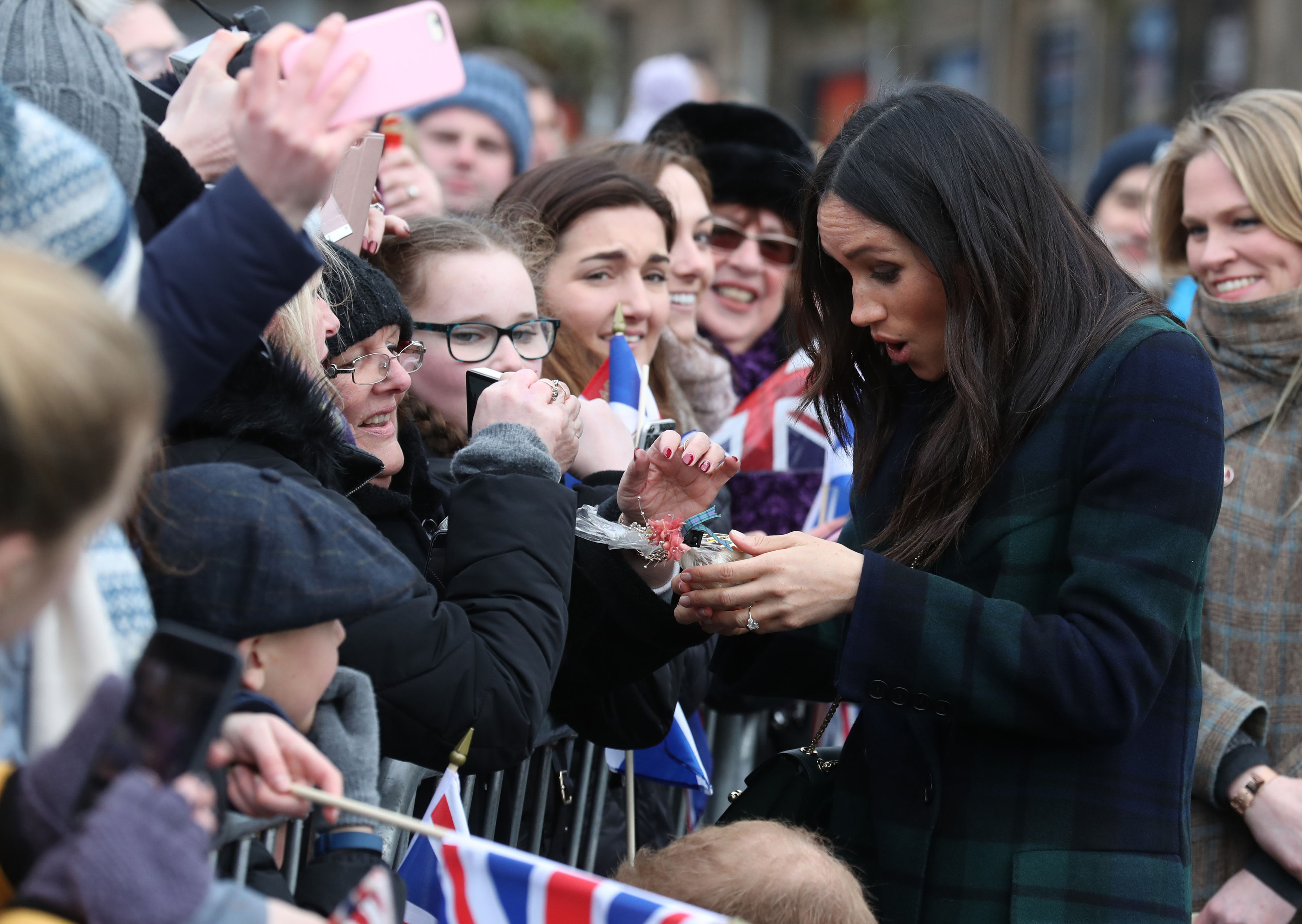 Britain's Prince Harry's fiancée US actress Meghan Markle reacts as she receives a gift during a walkabout on the Esplanade at Edinburgh Castle, during a visit to Scotland on February 13, 2018. (Andrew Milligan—AFP/Getty Images)