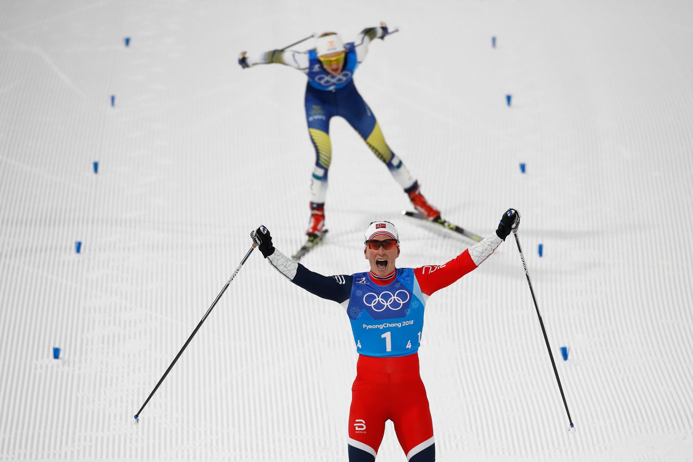 Norway's Marit Bjorgen crosses the finish line first during the women's 4x5km classic free style cross country relay on Feb. 17, 2018.