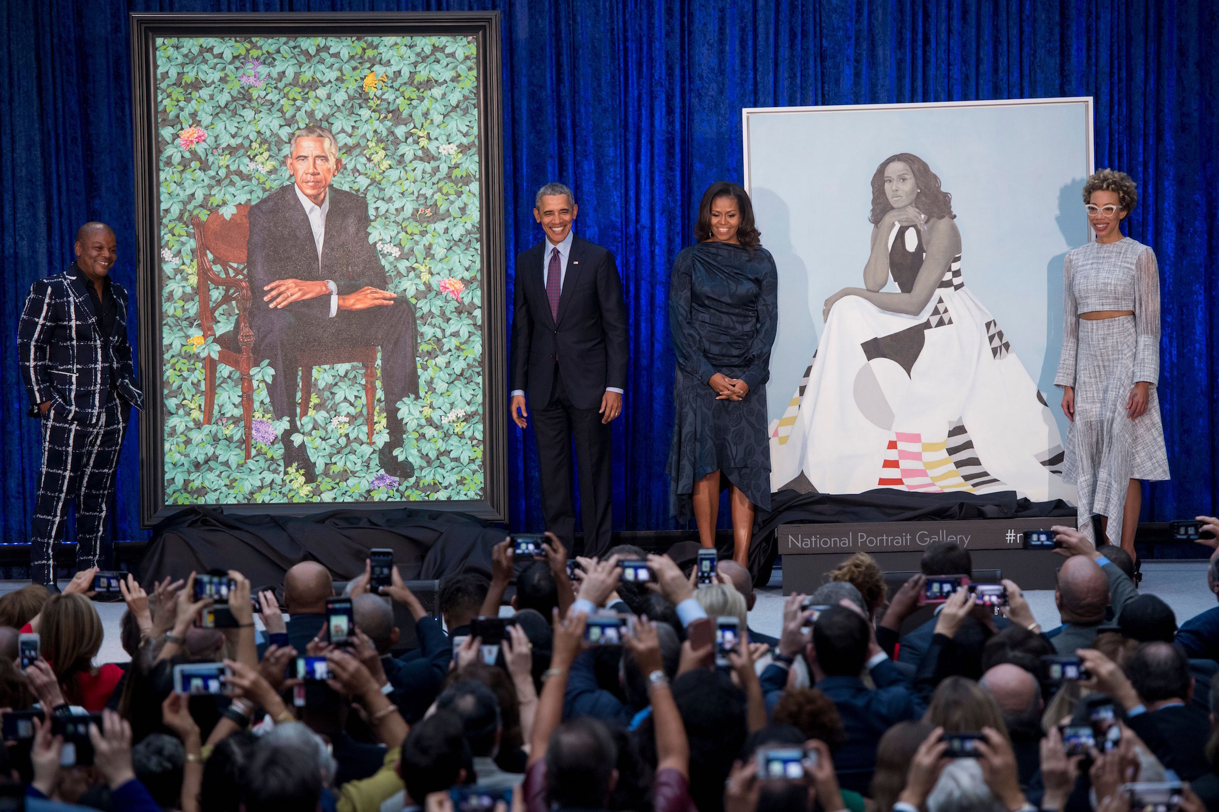 Former US President Barack Obama and First Lady Michelle Obama stand before their portraits and respective artists, Kehinde Wiley (L) and Amy Sherald (R), after an unveiling at the Smithsonian's National Portrait Gallery in Washington, D.C., on Feb. 12, 2018. (Saul Loeb—AFP/Getty Images)