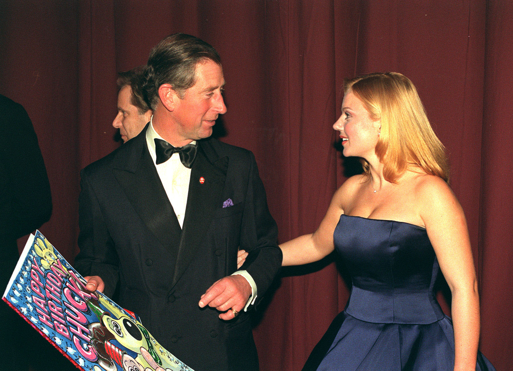 The Prince of Wales with former Spice Girl Geri Halliwell on his arm with a card presented to him backstage, after the Prince's Trust Comedy Gala at the Lyceum Theatre in London. (John Stillwell - PA Images—PA Images via Getty Images)