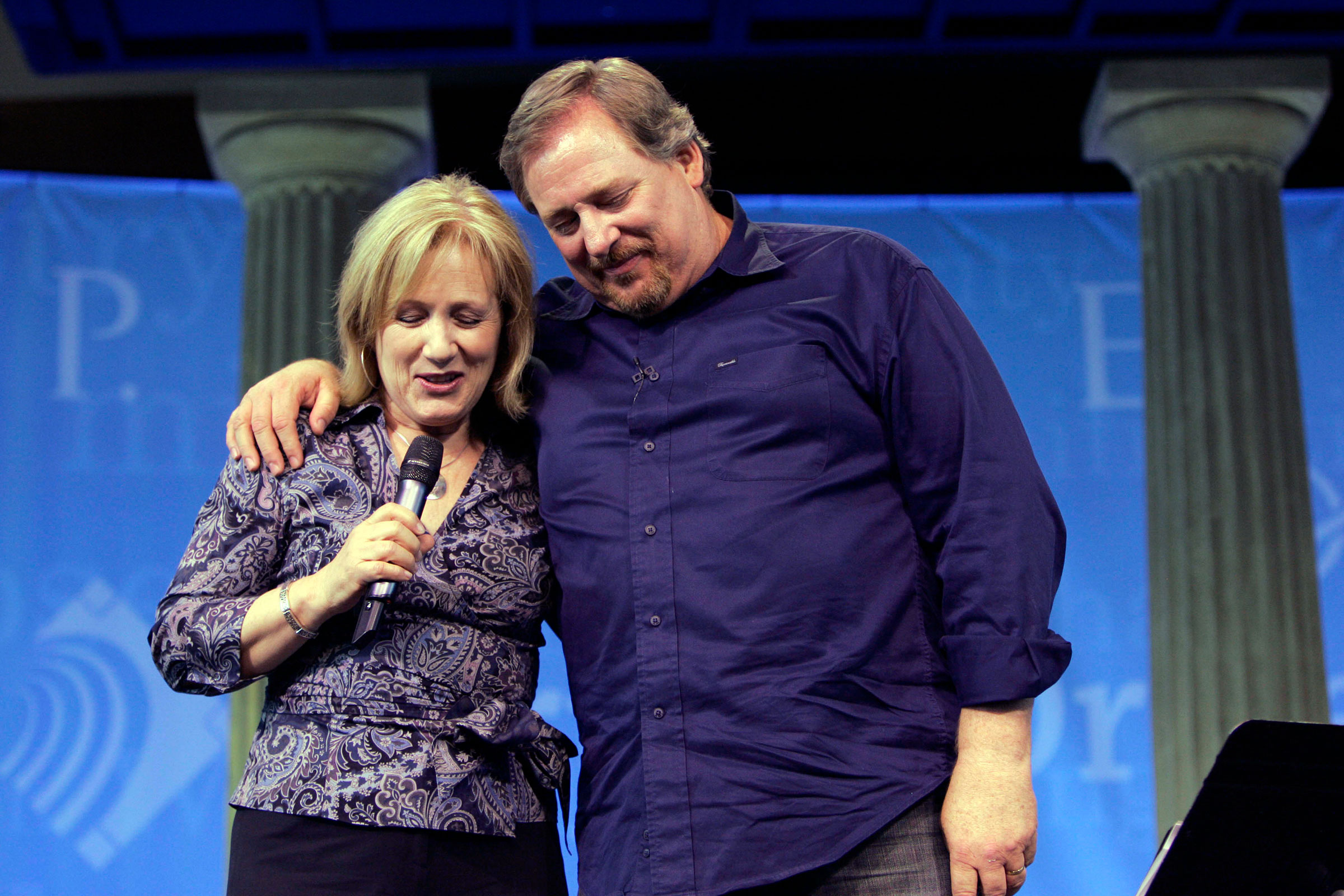 Kay Warren, left, is joined by her husband Pastor Rick Warren, as she leads a prayer at Saddleback Church in Lake Forest, May 20, 2008. (Ann Johansson—Corbis/Getty Images)
