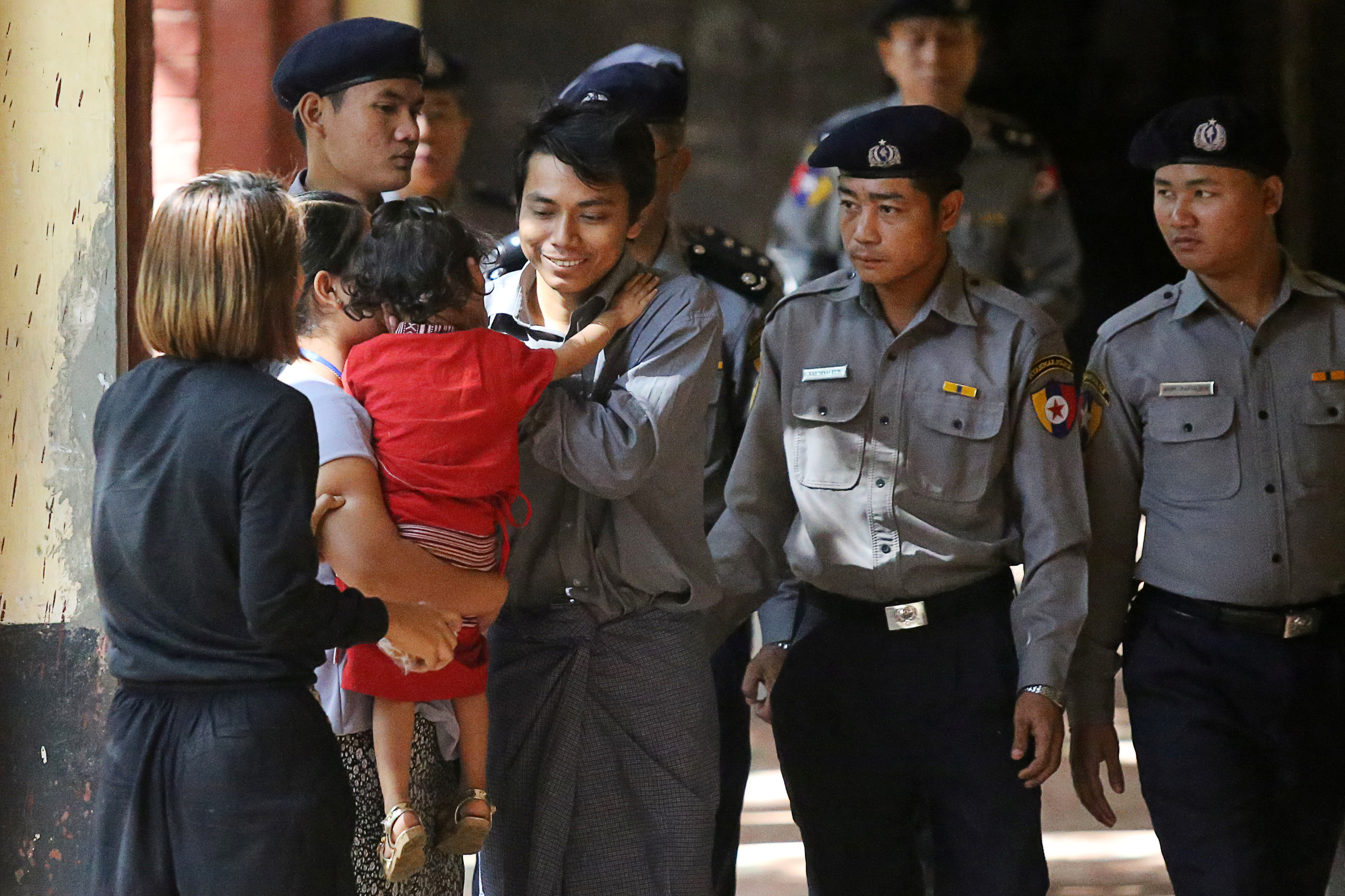 Detained Reuters journalist Kyaw Soe Oo greets his daughter while being escorted by police to a court hearing in Yangon, Myanmar on Feb. 1, 2018. (Ann Wang—Reuters)