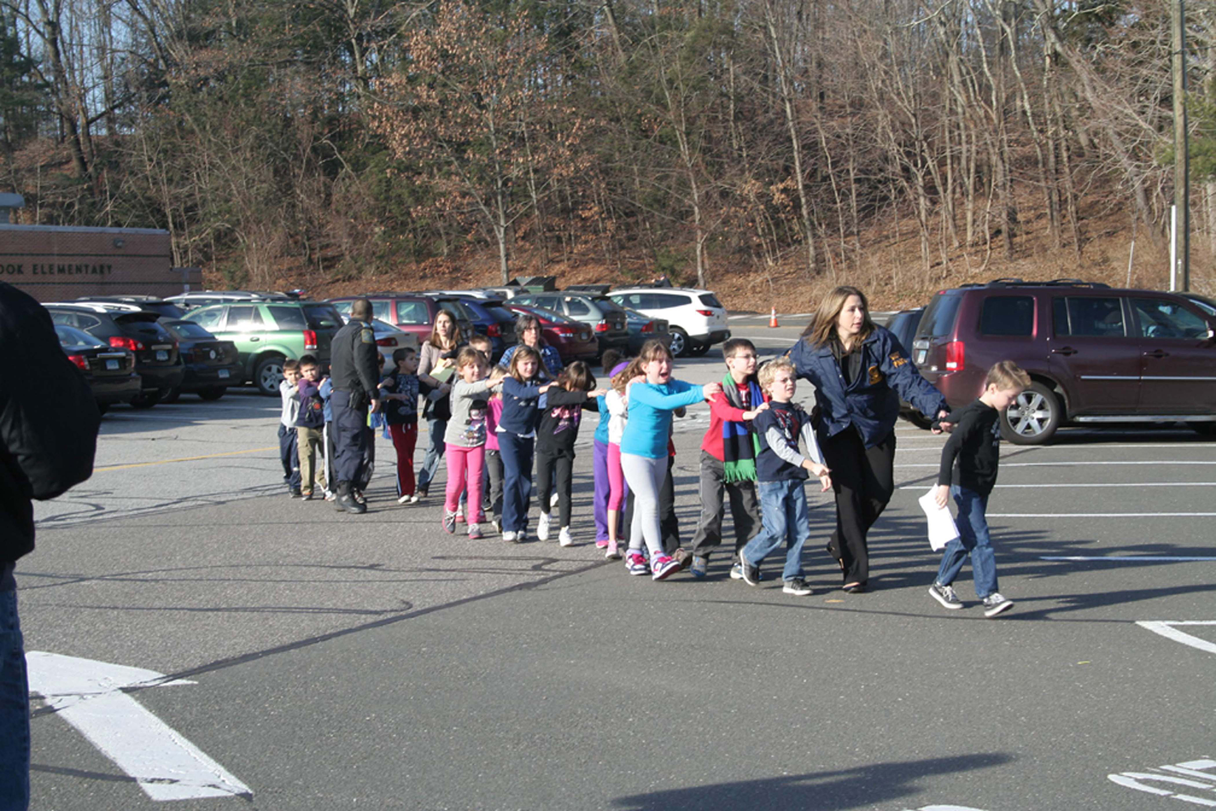 Connecticut State Police lead students from the Sandy Hook Elementary School to safety after a mass shooting on Dec. 14, 2012. (Shannon Hicks—Newtown Bee/Polaris)