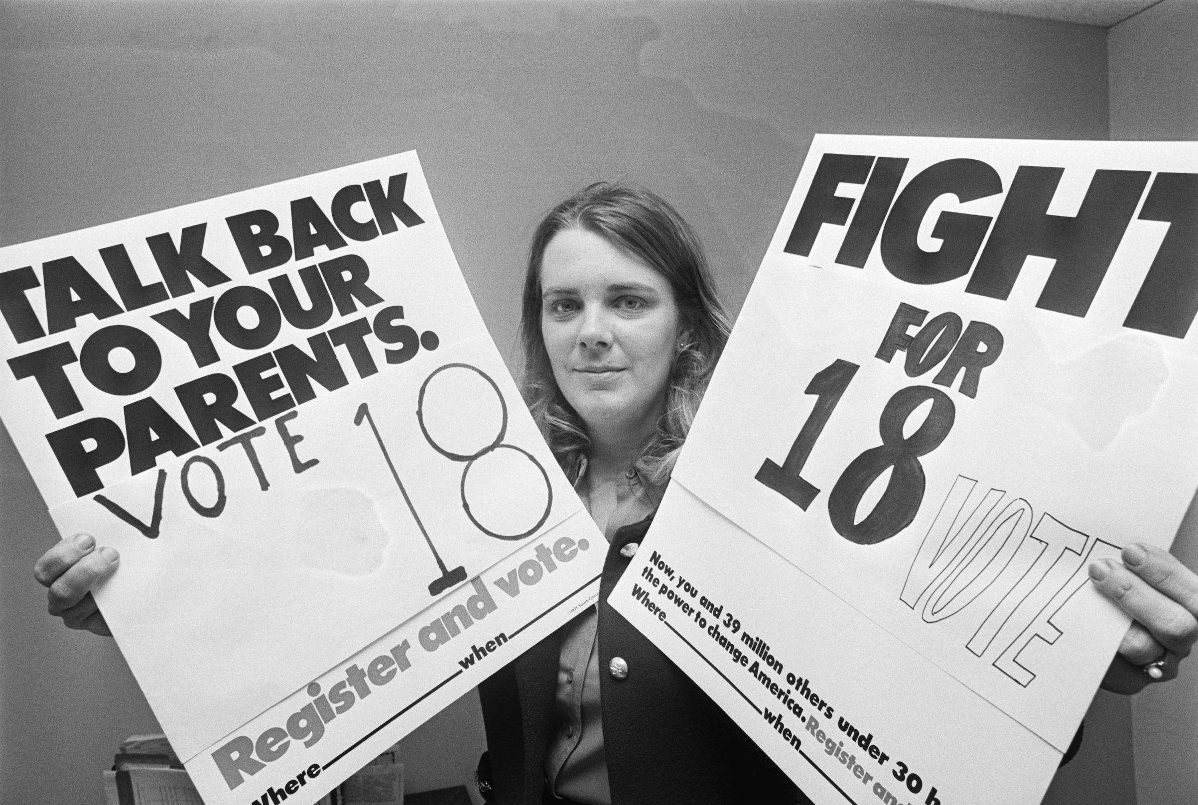 Patricia Keefer at her office in Washington, D.C. in 1971, holding up placards urging 18-year-olds (who have just received to right to vote) to use their power and vote. (Bettmann / Getty Images)