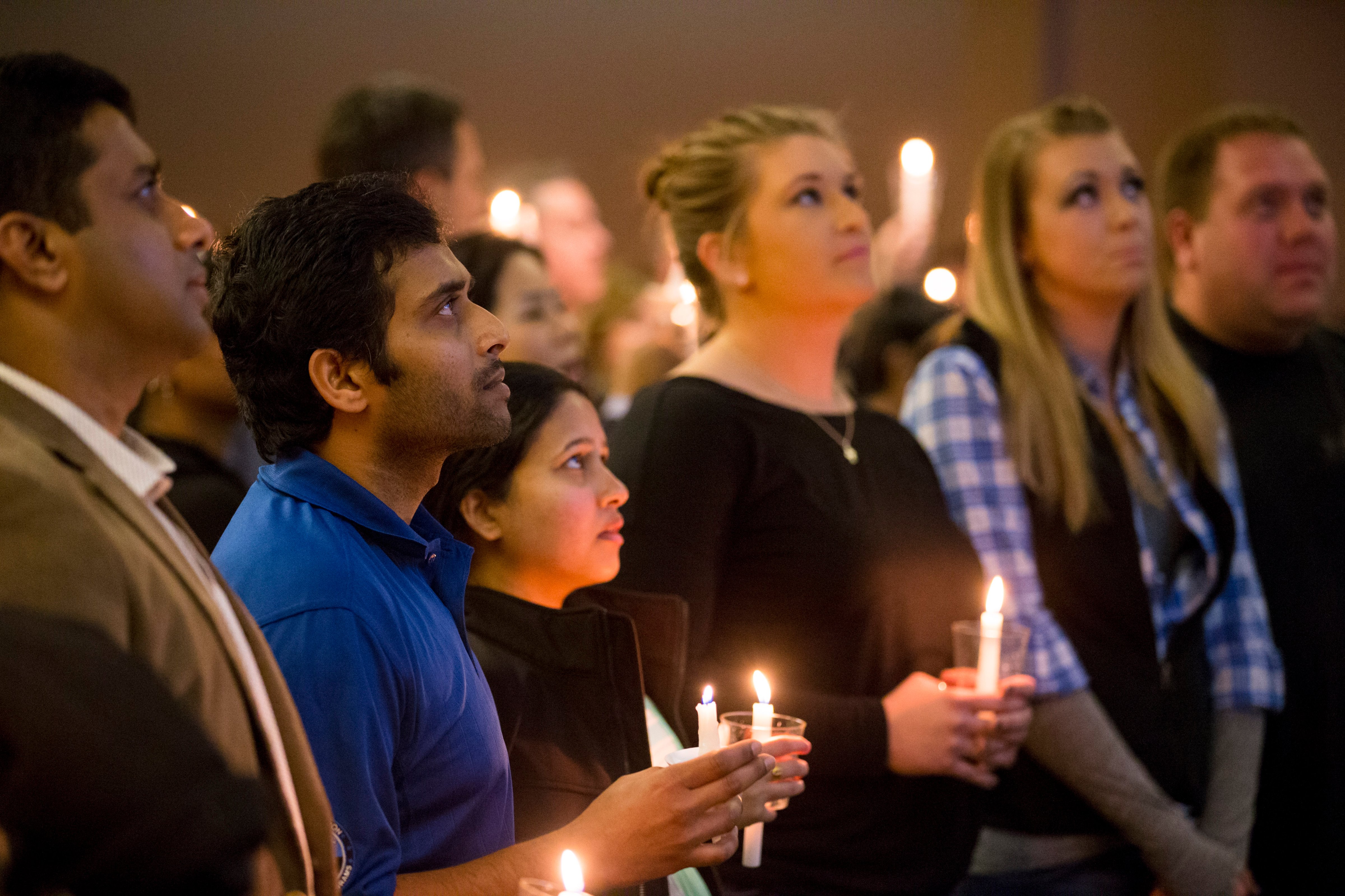 Alok Madasani, wife Reepthi Gangula; and Laura and Maggie Grillot, sisters to shooting victim Ian Grillot listen to the final songs at the end of the Prayer Vigil on February 26, 2017 at the Ball Conference Center in Olathe, Kansas. (Kyle Rivas—Getty Images)