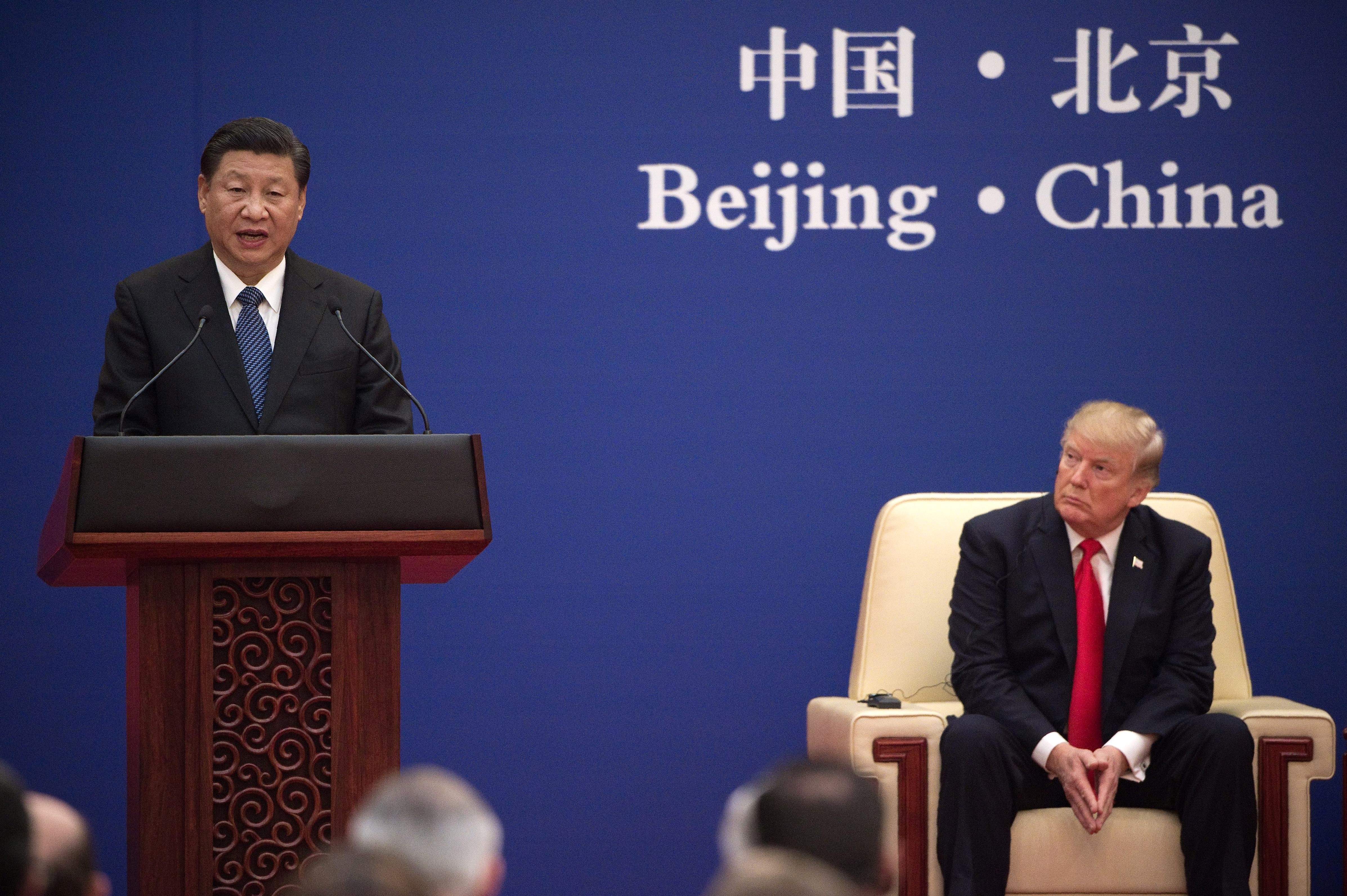 China's President Xi Jinping speaks next to US President Donald Trump during a business leaders event at the Great Hall of the People in Beijing on Nov. 9, 2017. (Nicolas Asfouri—AFP/Getty Images)