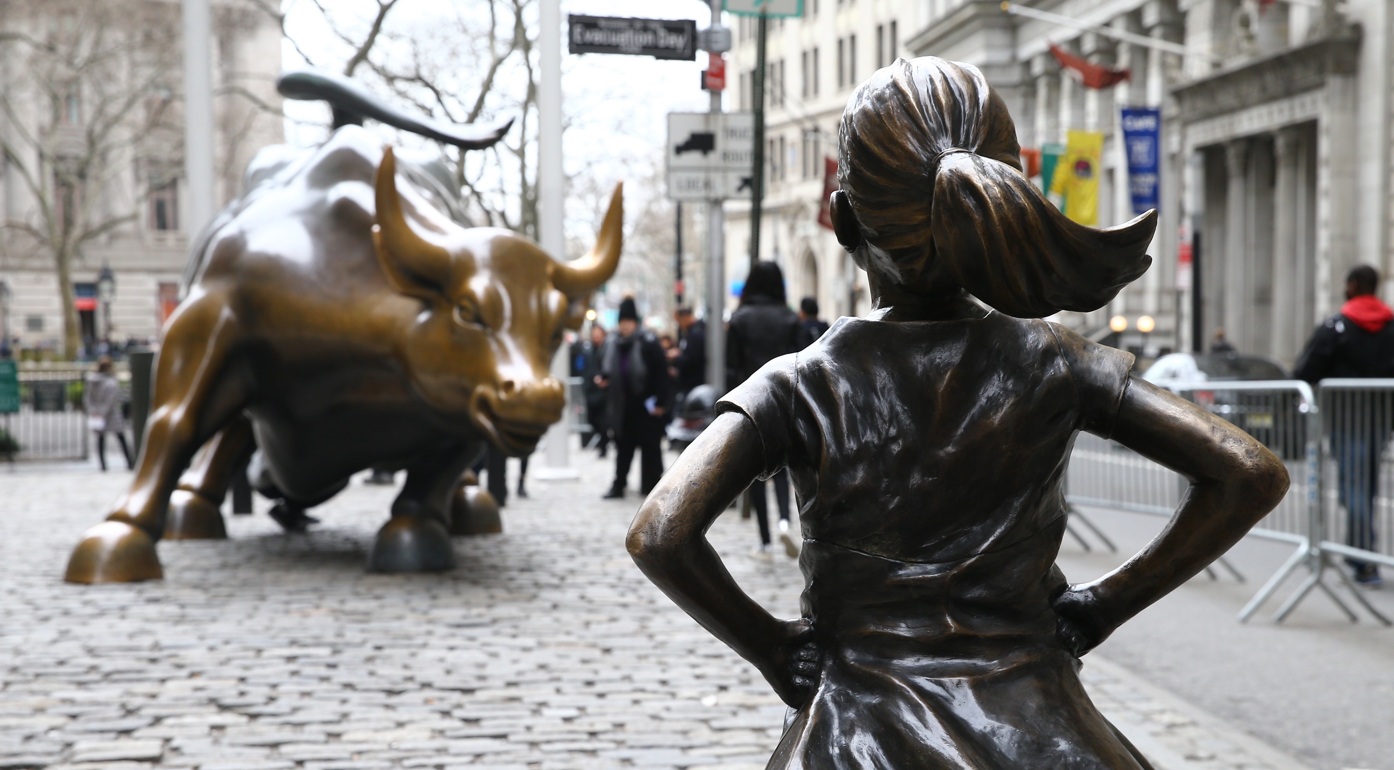 The "Fearless Girl" statue, a four-foot statue of a young girl, defiantly looks up the iconic Wall Street "Charging Bull" sculpture in New York City, United States on March 29, 2017.  "Fearless Girl" statue was installed in front of the bronze "Charging Bull" for International Women's Day earlier this month to draw attention to the gender pay gap and lack of gender diversity on corporate boards in the financial sector. The statue will remain at her post until February 2018. (Photo by Volkan Furuncu—Anadolu Agency/Getty Images)