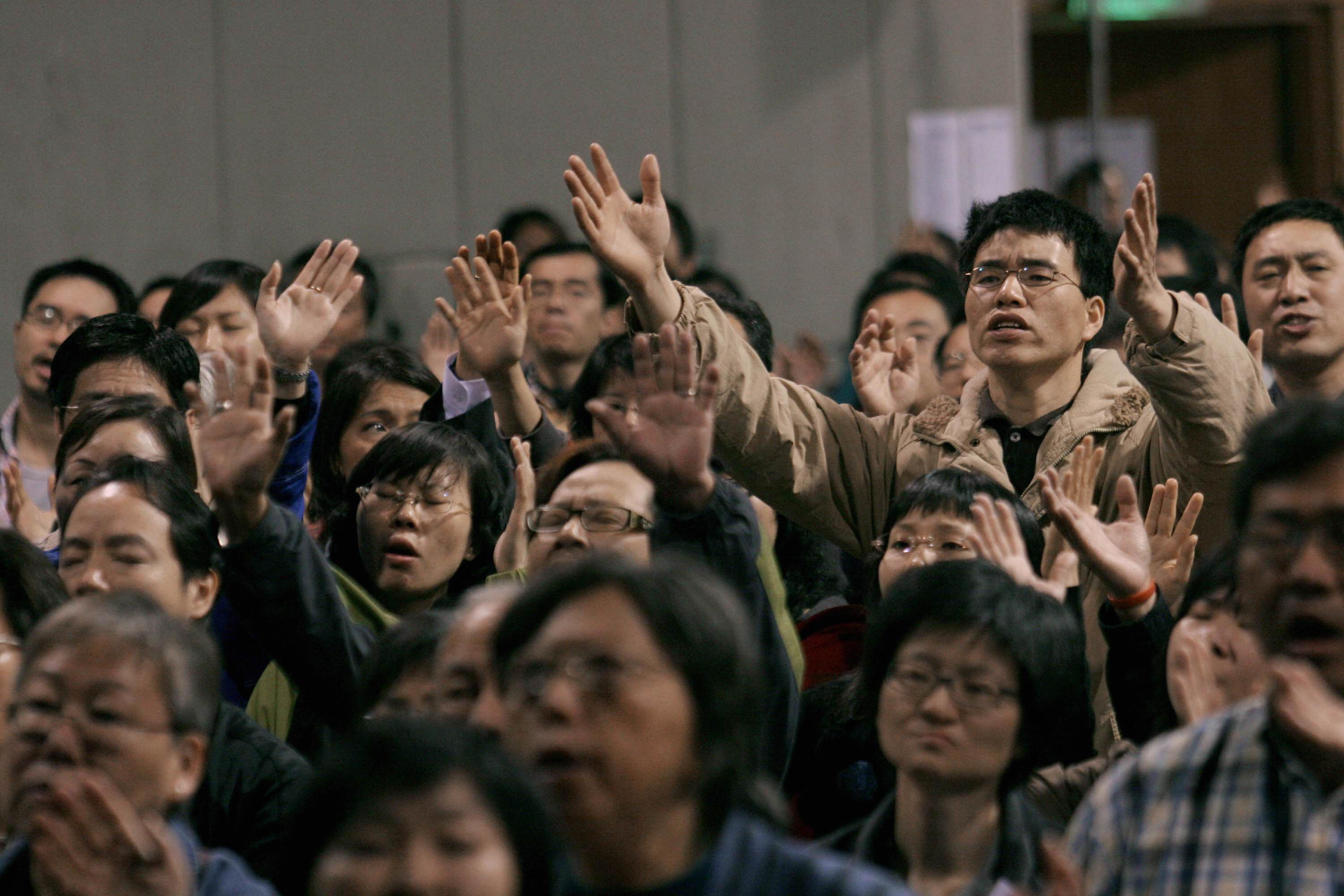 Participants raise their hands in prayer during the first Global Chinese Alpha conference in Hong Kong, April 10, 2007. (AFP/Getty Images)