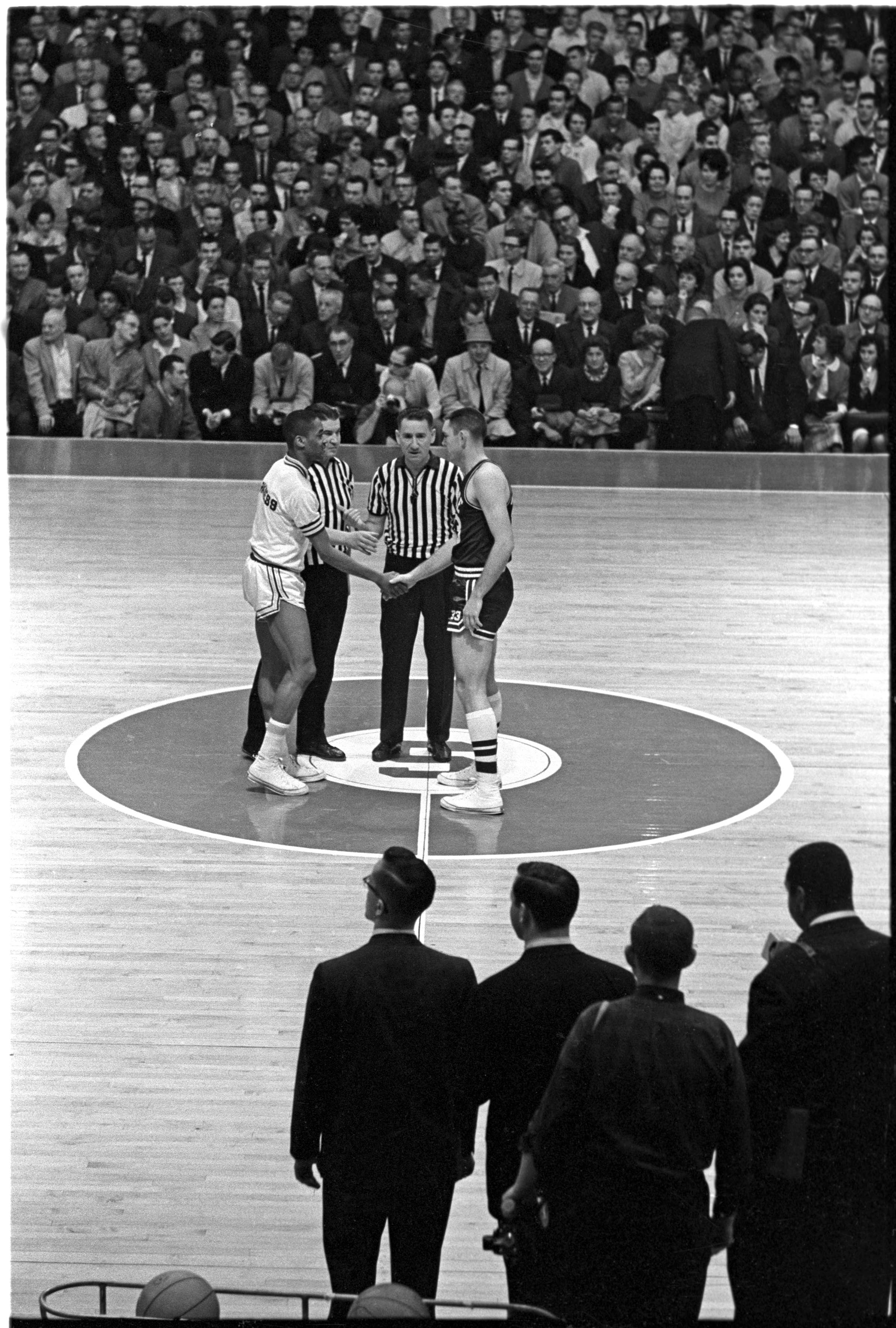 Loyola player Jerry Harkness extends his hand to Joe Dan Gold of Mississippi State on March 15, 1963, before the tip-off of an NCAA tournament game in East Lansing, Michigan. (Rich Clarkson—NCAA Photos/Getty Images)