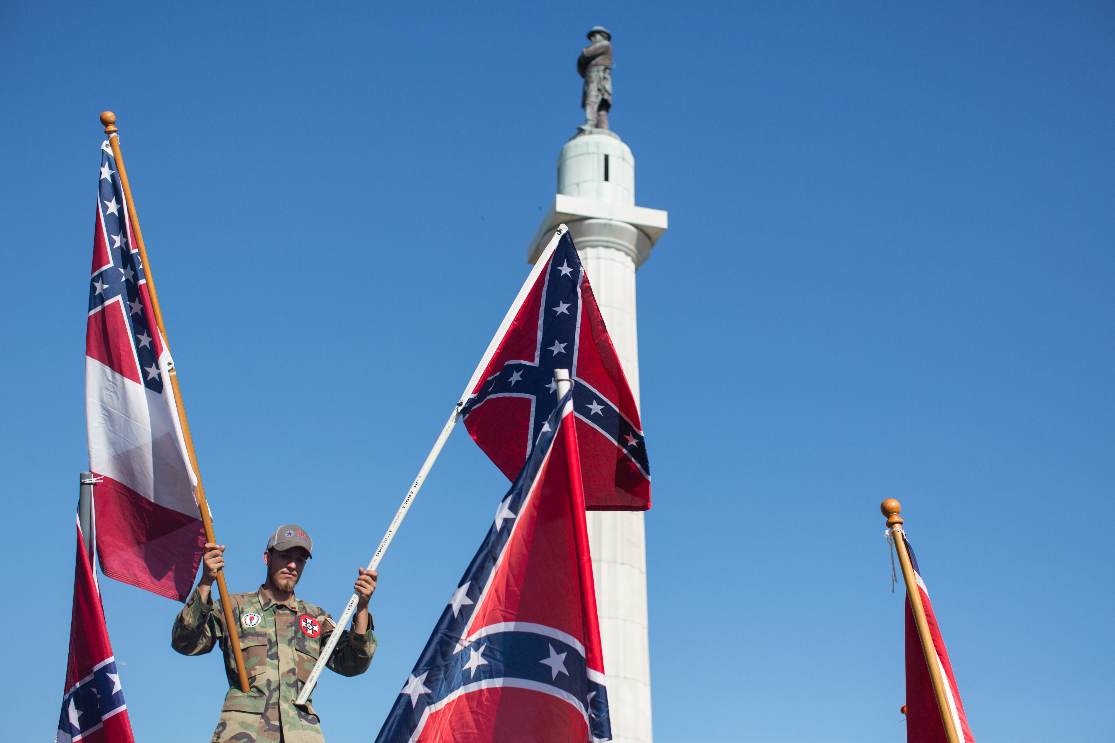 NEW ORLEANS, MAY 7, 2017: A person in opposition to the removal of monuments to the Confederacy holds confederate flags against the Robert E. Lee statue in New Orleans, Louisiana. (Photo by Annie Flanagan for The Washington Post via Getty Images) (The Washington Post/Getty Images)