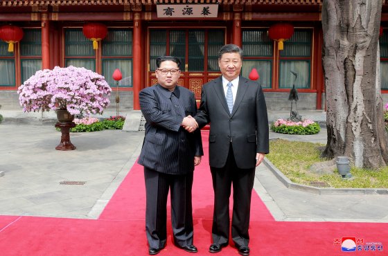 Kim Jong Un and Xi Jinping shake hands at the Diaoyutai State Guesthouse