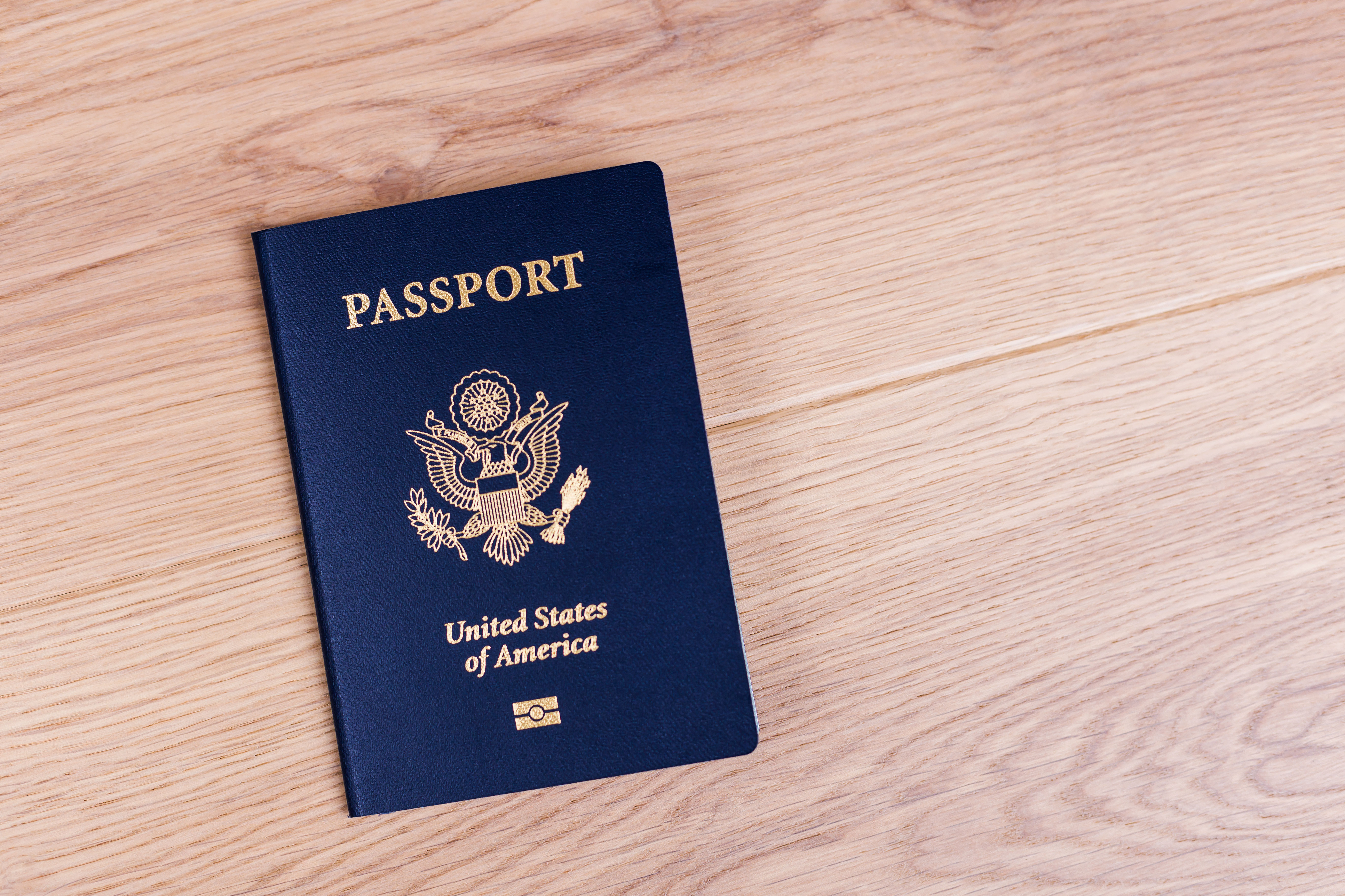 Top view of american passport on wooden desktop (ismagilov—Getty Images/iStockphoto)