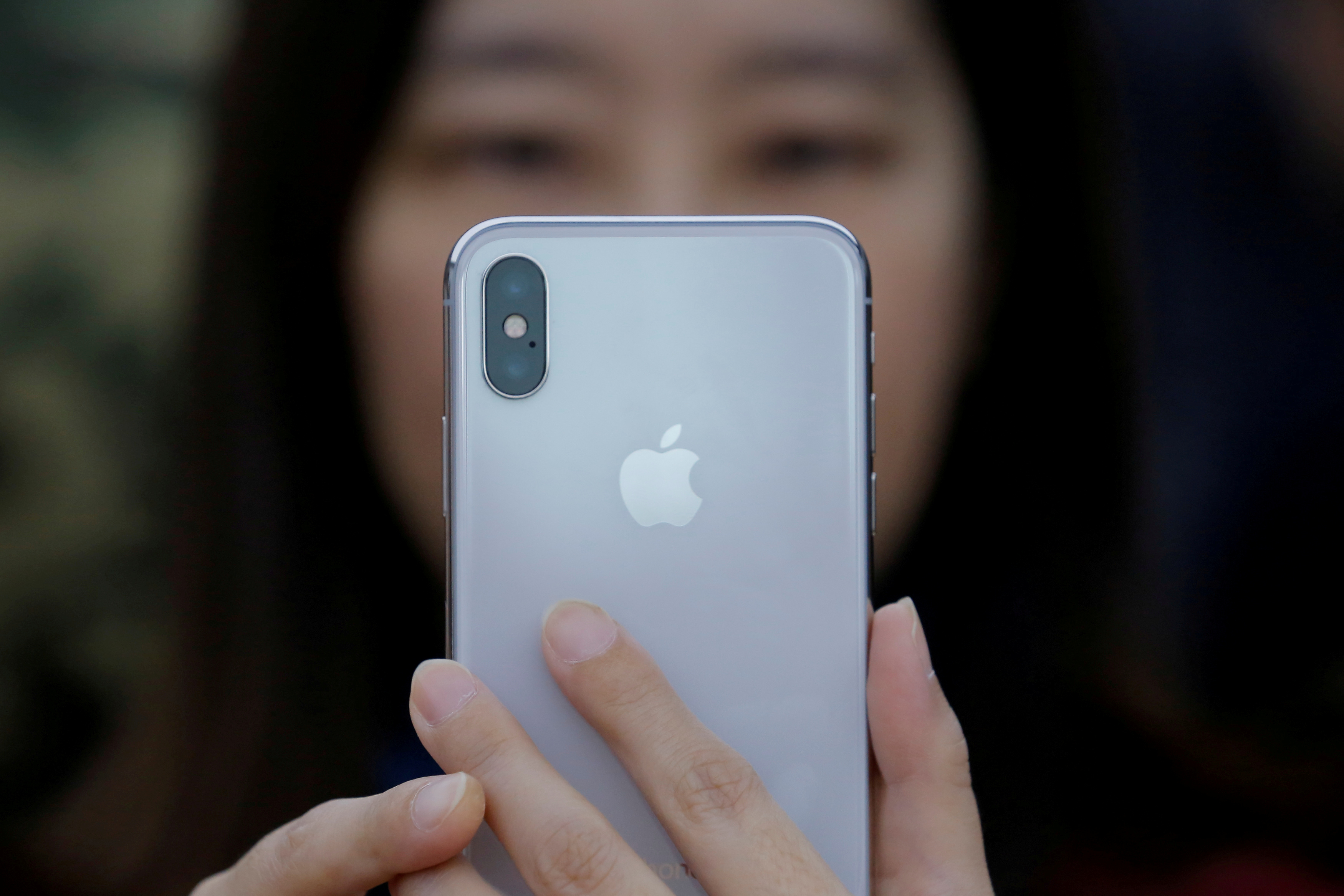 A woman uses an iPhone X during a presentation in Beijing, China on Oct. 31, 2017. (Thomas Peter&mdash;Reuters)