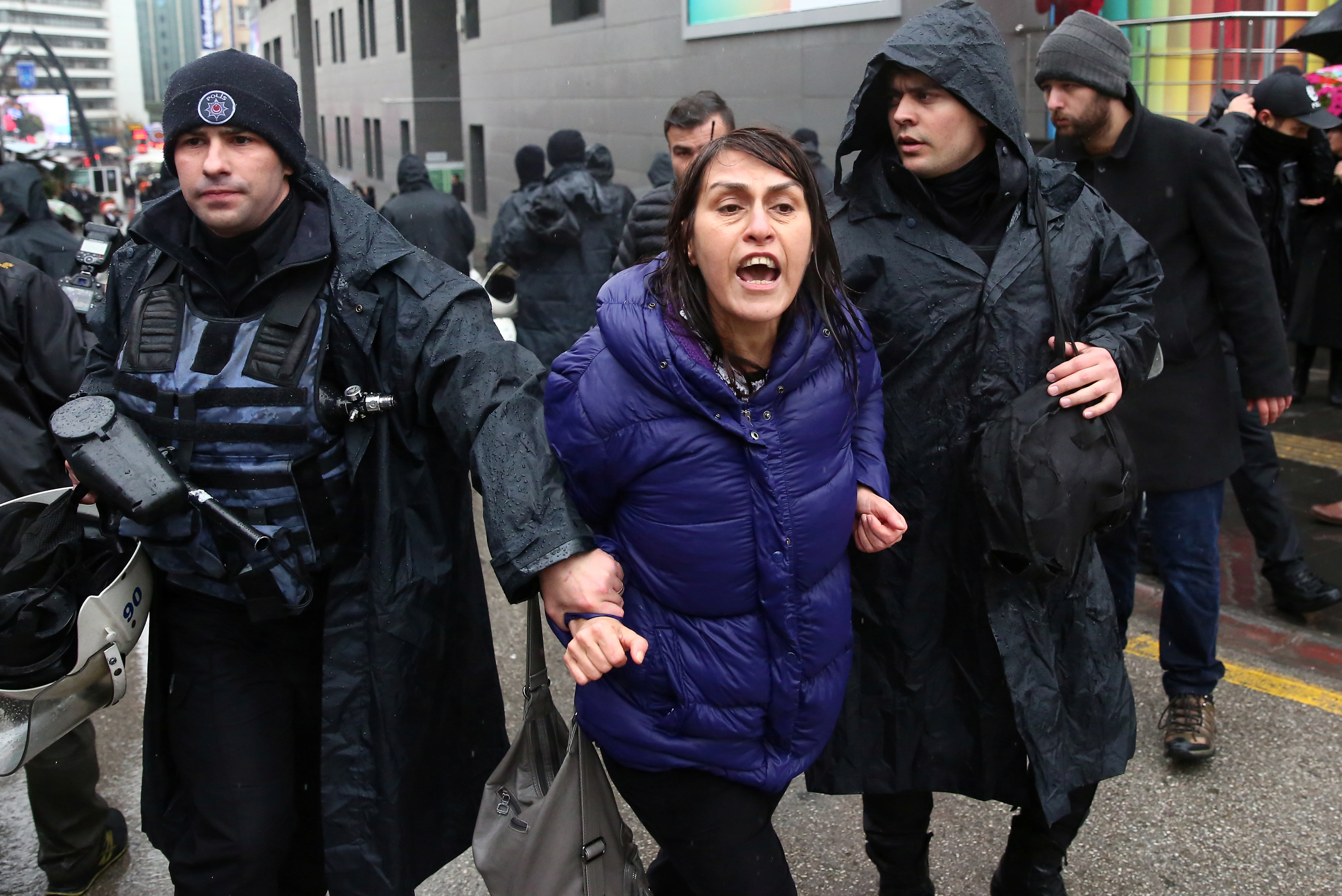 A woman is detained by riot police during a Women's Day rally in Ankara