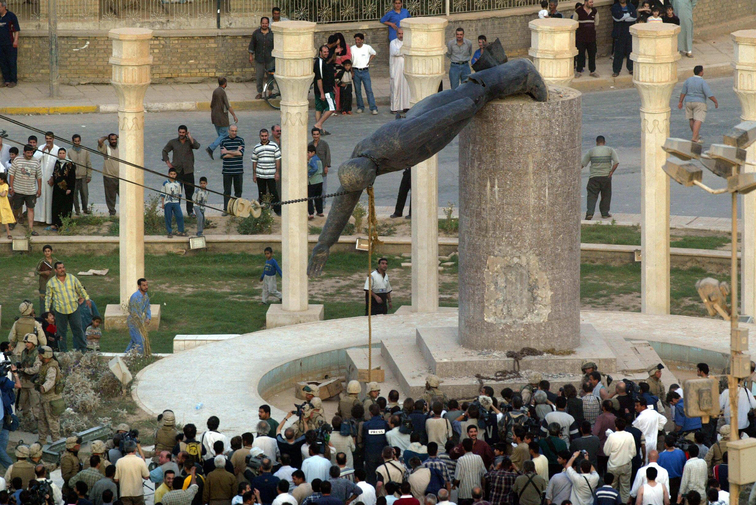 Iraqis watch a statue of Saddam Hussein falling in Baghdad on April 9, 20013. The ousted dictator was hanged in December 2006. (Patrick Baz—AFP/Getty Images)