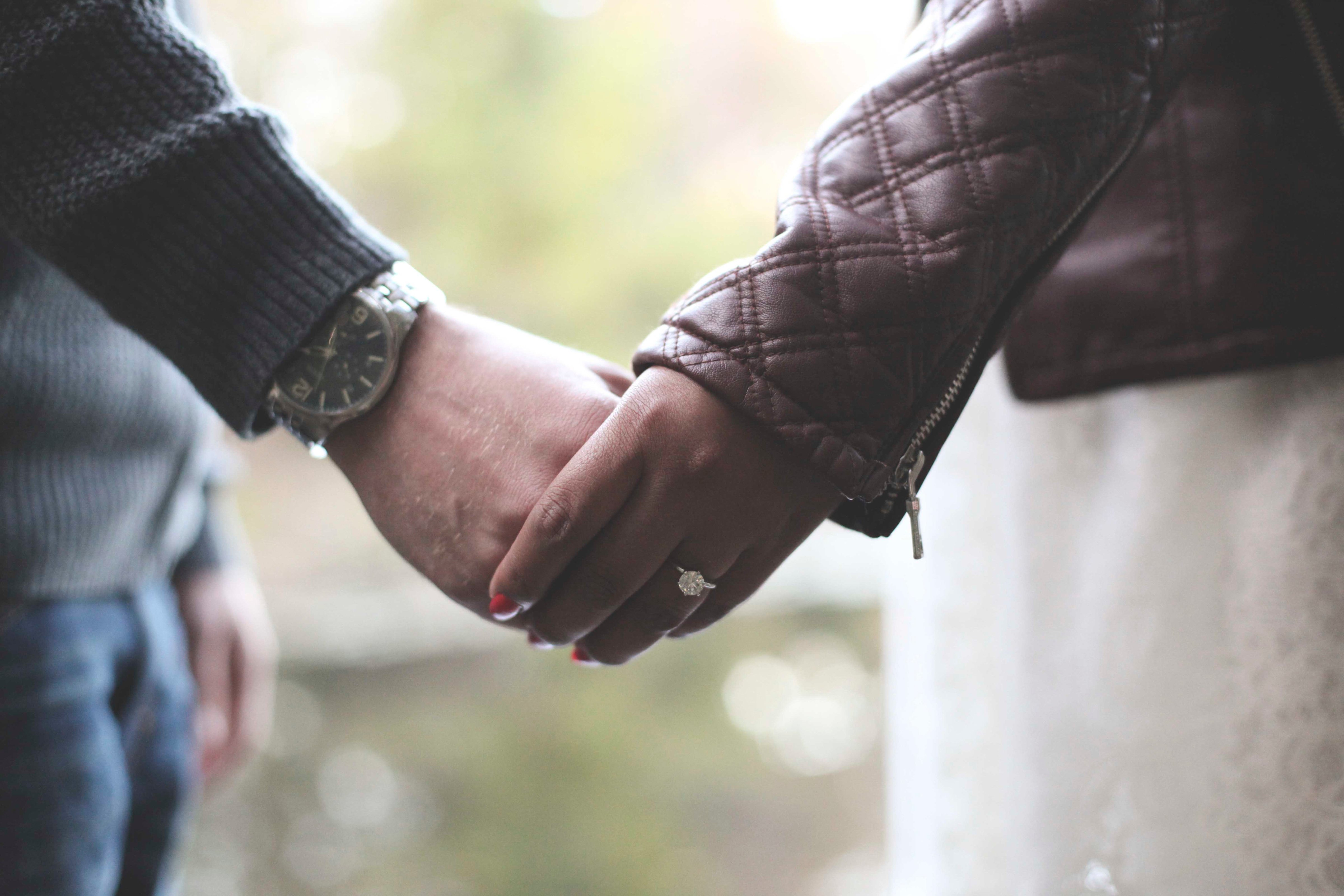 Close up of engaged couple holding hands