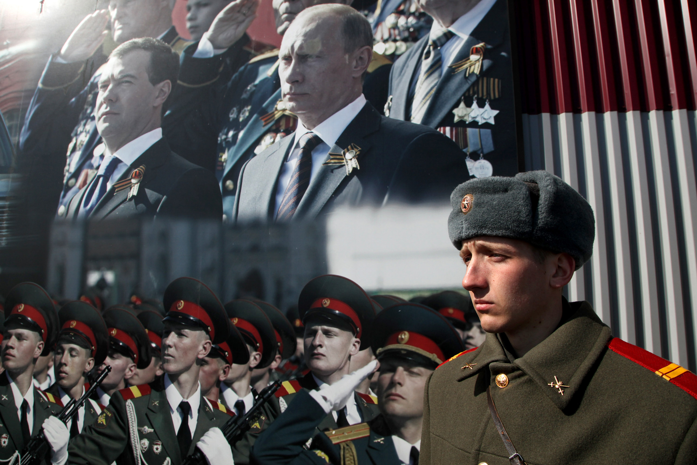 A Russian soldier stands in front of poster with portraits of Russian President-elect Vladimir Putin and outgoing President Dmitry Medvedev during a rehearsal for the Victory Day parade near Moscow on April 4, 2012. The parade is dedicated to the anniversary of the Soviet victory over Nazi Germany in World War II. (Sasha Mordovets—Getty Images)