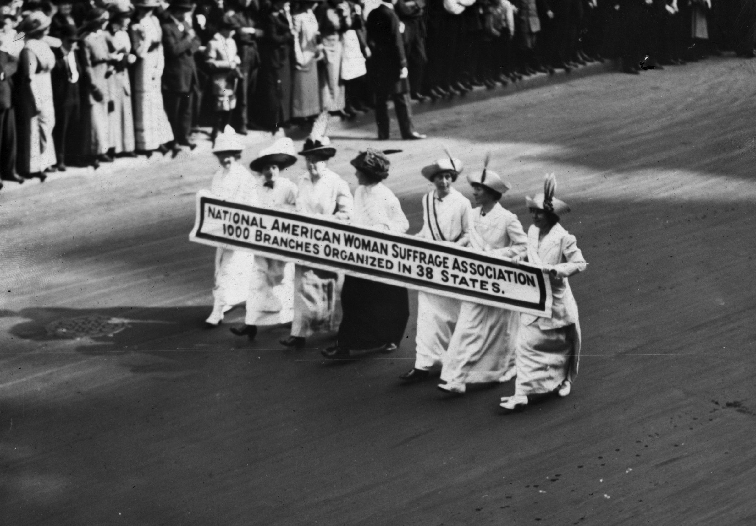 Members of the National American Woman Suffrage Association marching with a banner at the New York Suffragette Parade on May 3, 1913 (Paul Thompson—Getty Images)