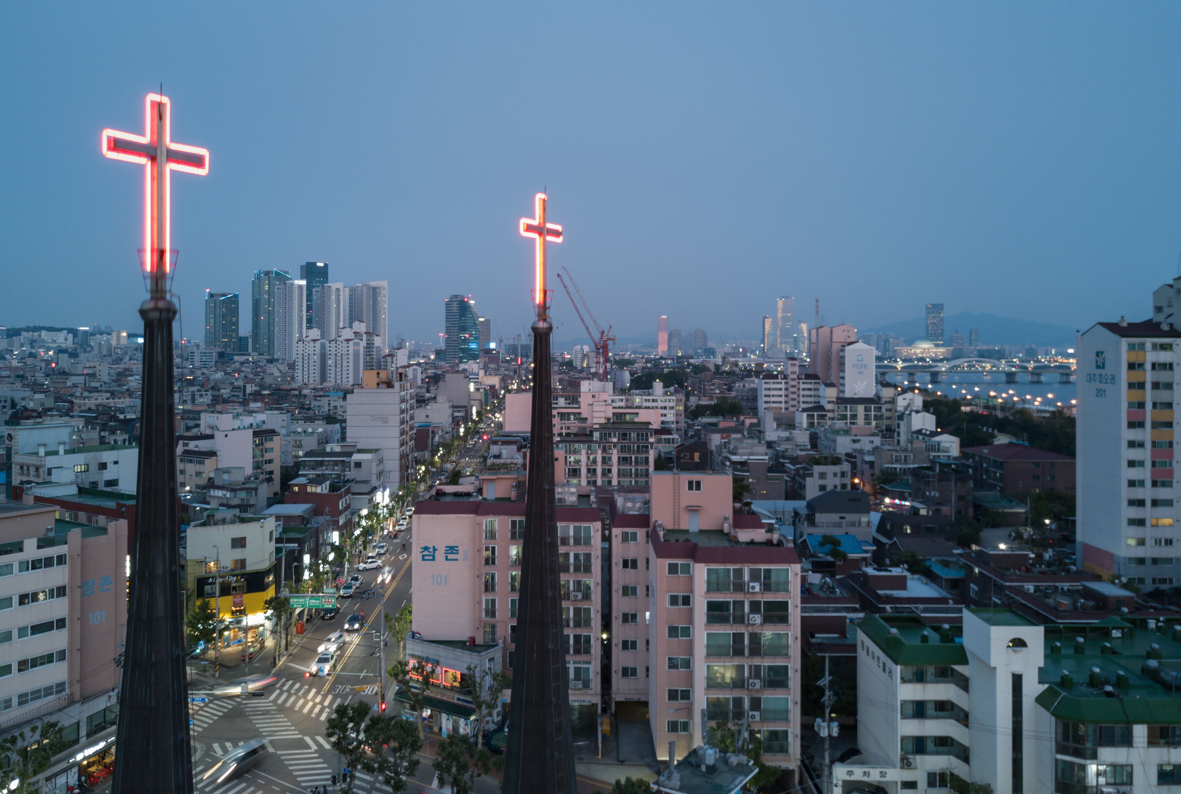 Illuminated crosses are displayed above a church, before the city skyline of Seoul, on May 18, 2017. (Ed Jones—AFP/Getty Images)