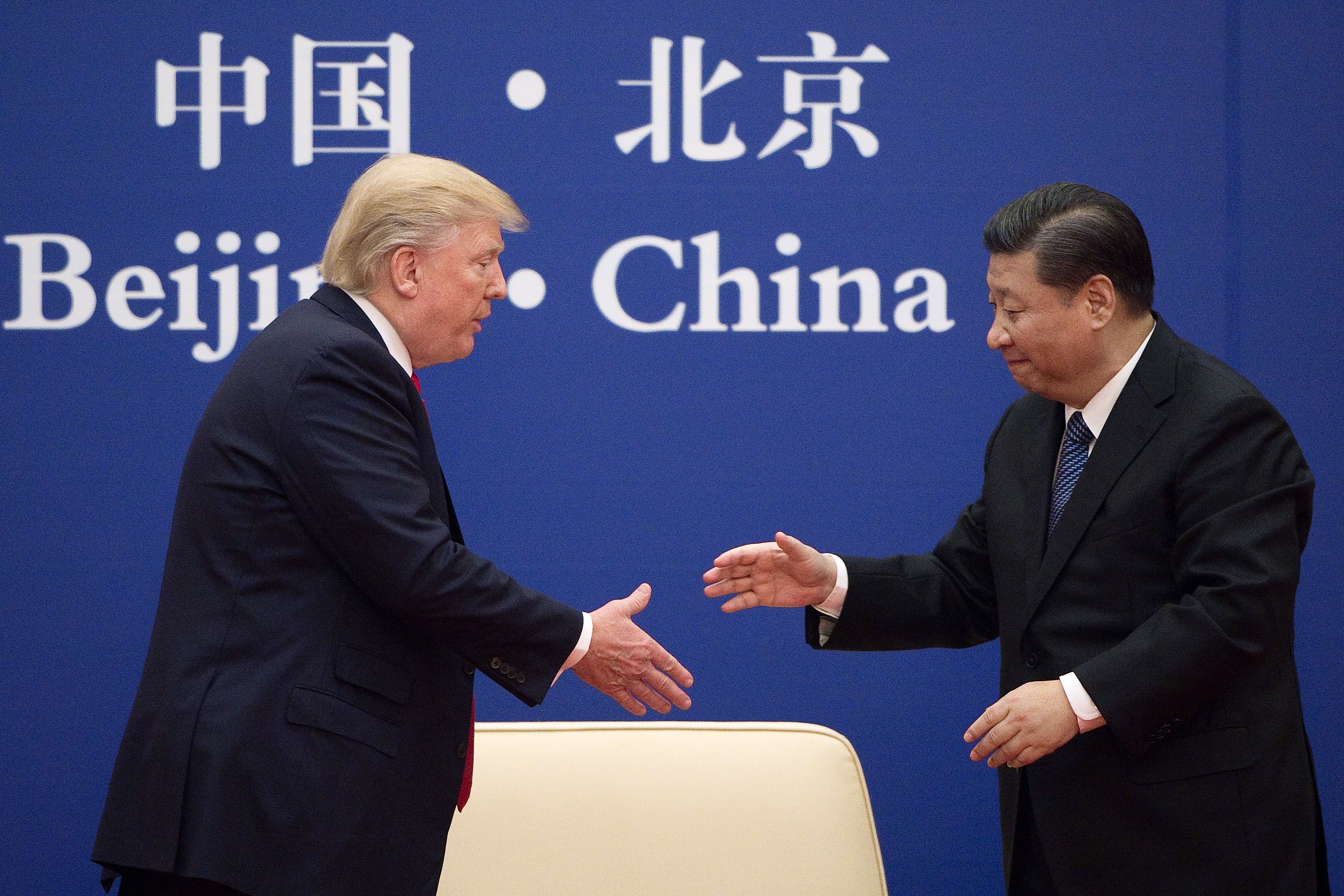 China's President Xi Jinping shakes hands with U.S. President Donald Trump during a business leaders event at the Great Hall of the People in Beijing on November 9, 2017. (Nicolas Asfouri—AFP/Getty Images)