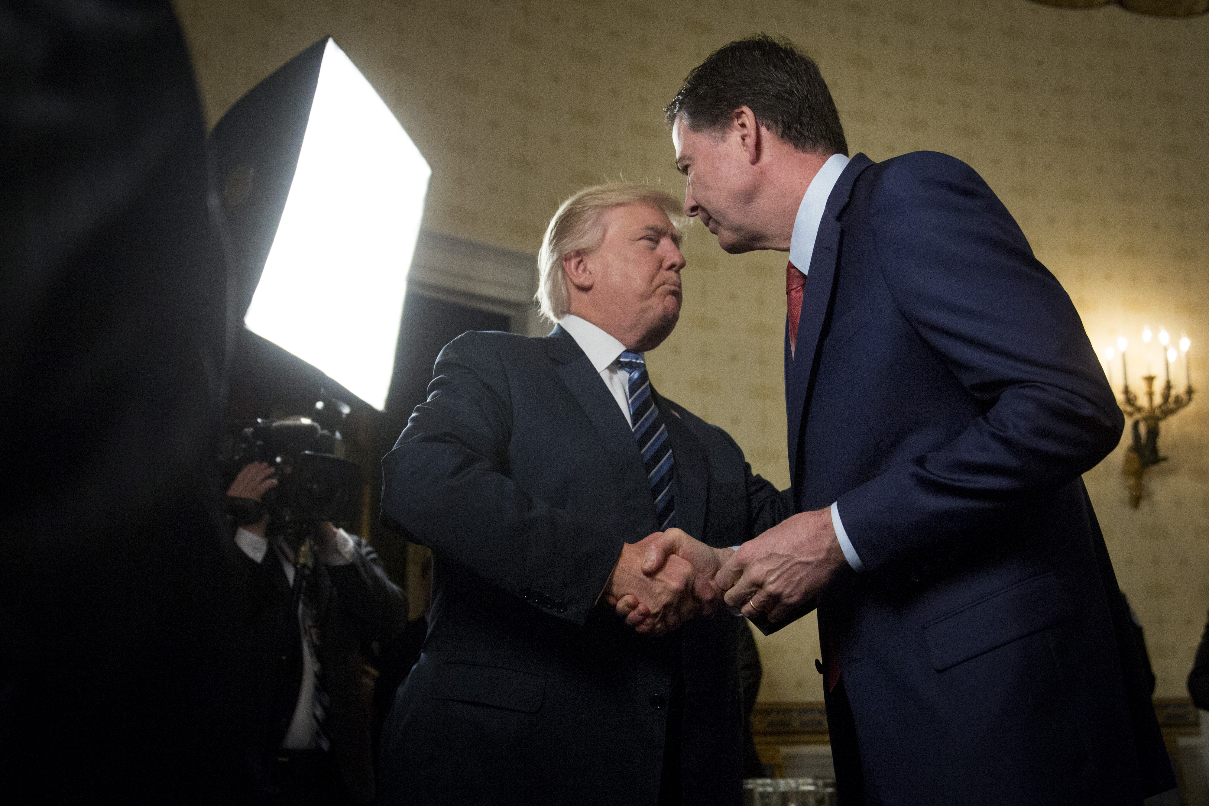 U.S. President Donald Trump, left, shakes hands with James Comey, director of the Federal Bureau of Investigation (FBI), during an Inaugural Law Enforcement Officers and First Responders Reception in the Blue Room of the White House in Washington, D.C., on Jan. 22, 2017. (Andrew Harrer—Bloomberg via Getty Images)
