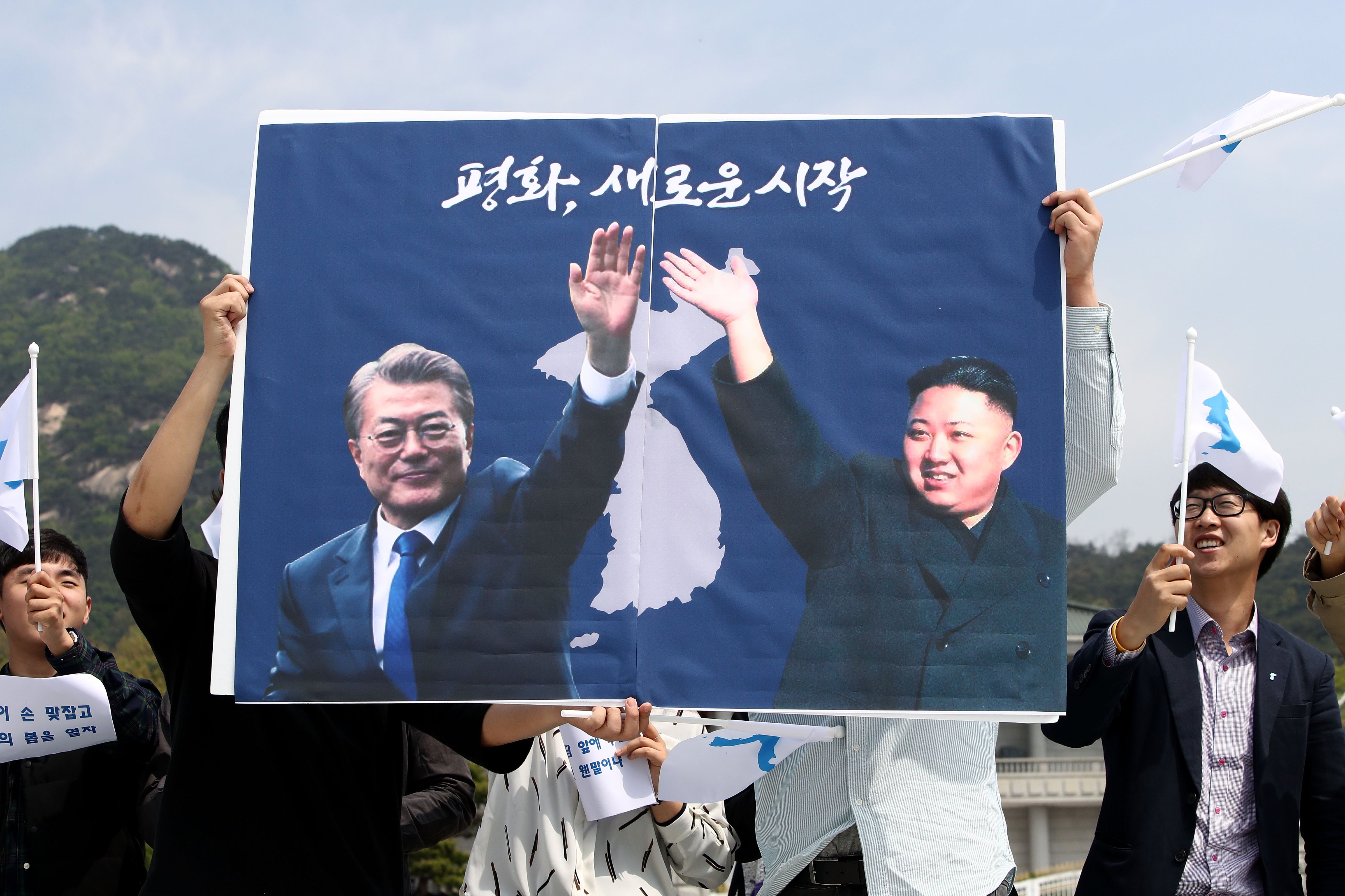 South Koreans hold up placards of South Korean President Moon Jae-In and North Korean leader Kim Jung-Un in front of Presidential Blue House  in Seoul, South Korea on April 26, 2018. (Chung Sung-Jun—Getty Images)
