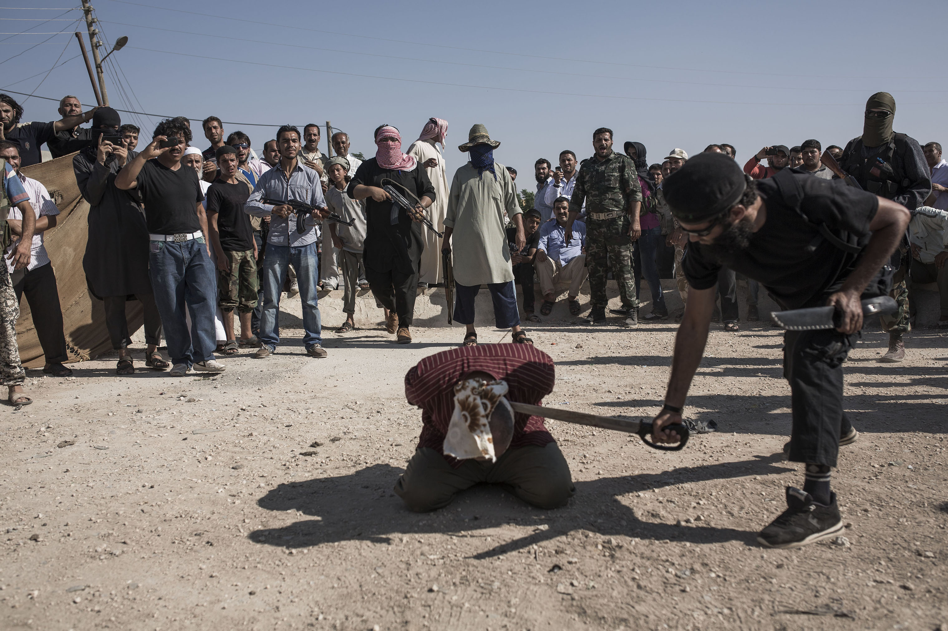 A soldier from Assad's regime—charged with being an informant, murder, stealing and delivering 10 Free Syrian Army soldiers to the regime—is executed by ISIS in the town of Ehtemlat in northern Syria, 2013. (Emin Özmen—Magnum Photos)