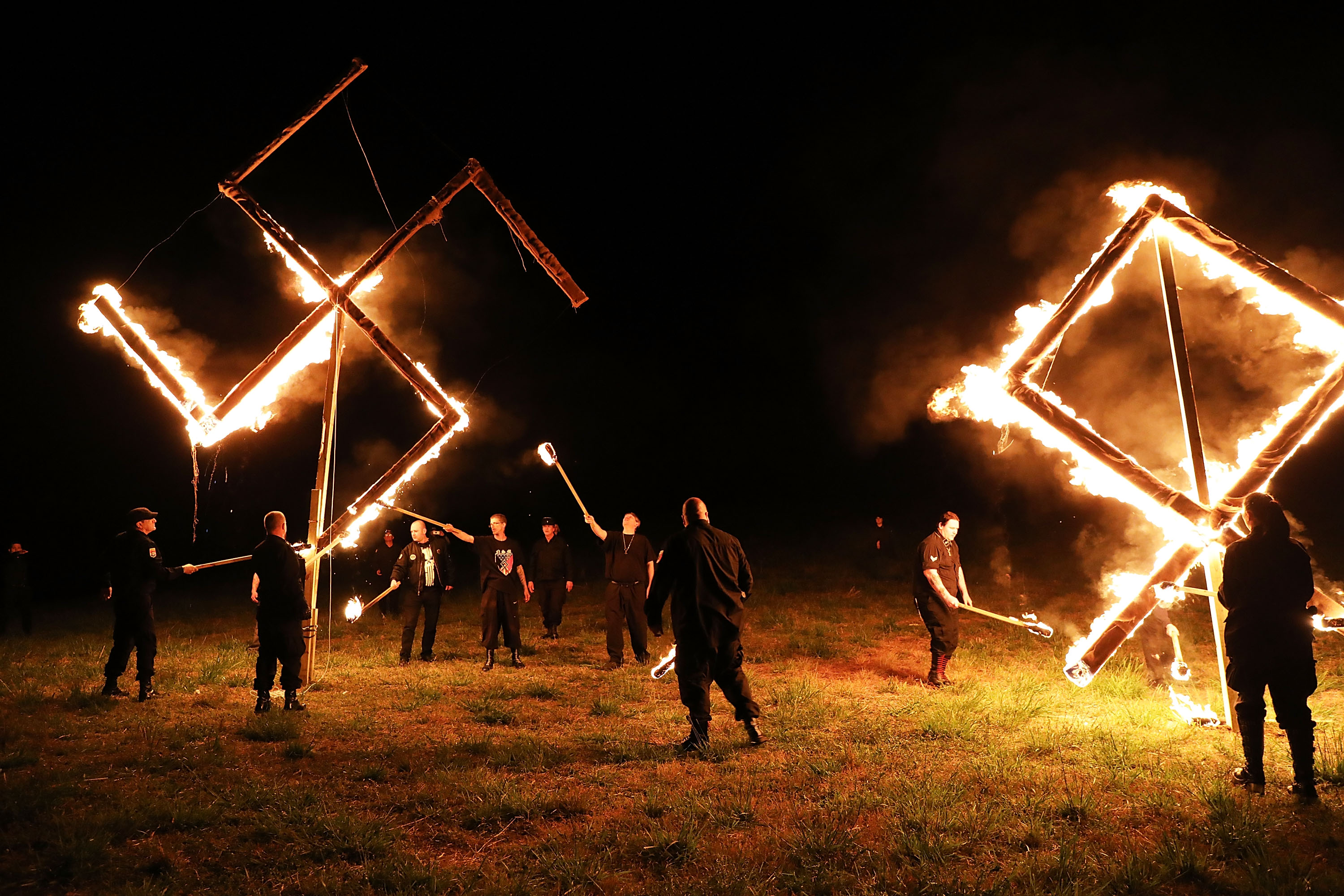 Members of the National Socialist Movement, one of the largest neo-Nazi groups in the US, hold a swastika burning after a rally on April 21, 2018 in Draketown, Georgia. Community members had opposed the rally in Newnan and came out to embrace racial unity in the small Georgia town. Fearing a repeat of the violence that broke out after Charlottesville, hundreds of police officers were stationed in the town during the rally in an attempt to keep the anti racist protesters and neo-Nazi groups separated (Spencer Platt - Getty Images)