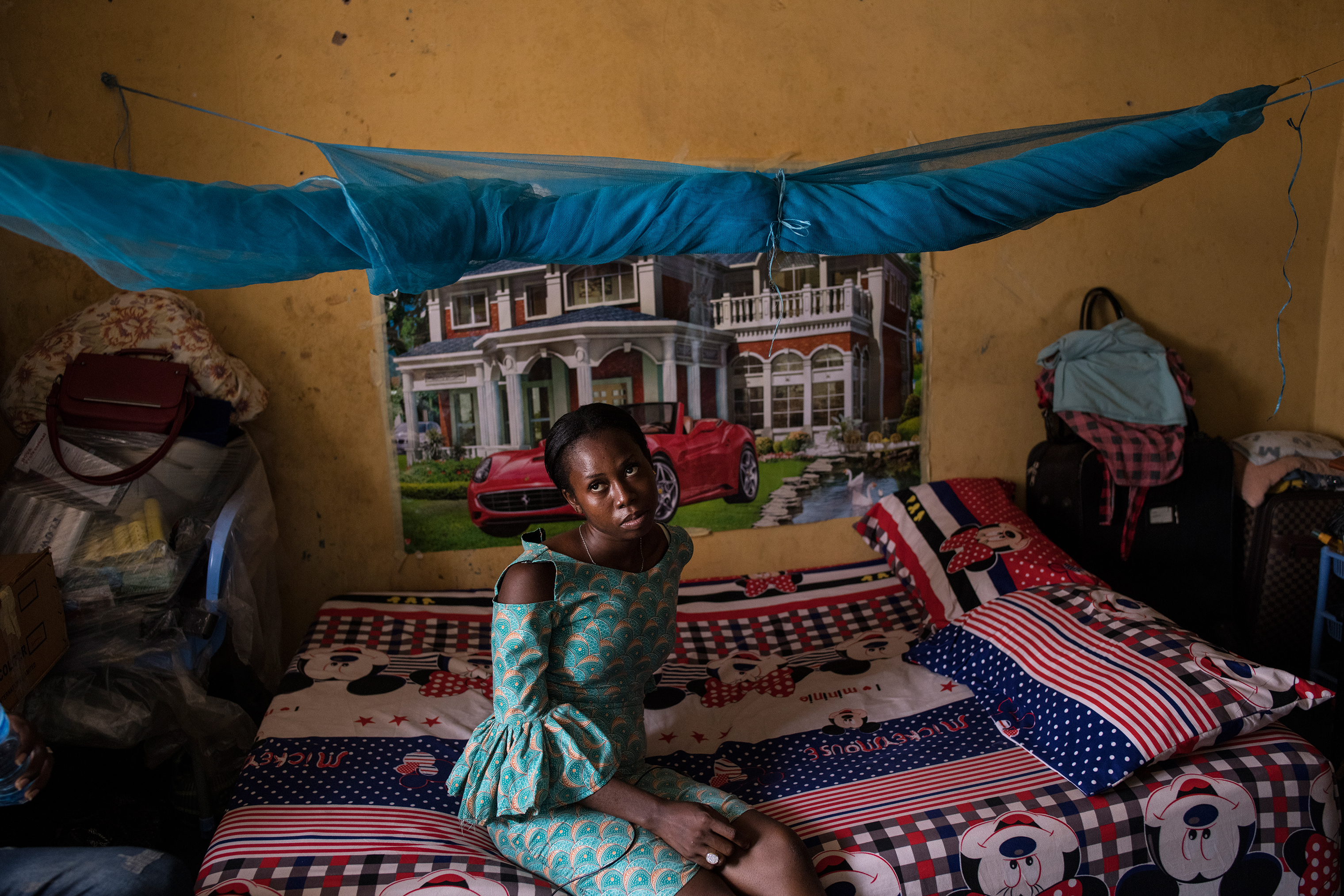 Florence, 24, about 10 days after getting married in Benin City on March 26. She jokes that she would love to have a house and a car—like the one in the poster behind her—once her hair salon business takes off. (Lynsey Addario—Verbatim for TIME)