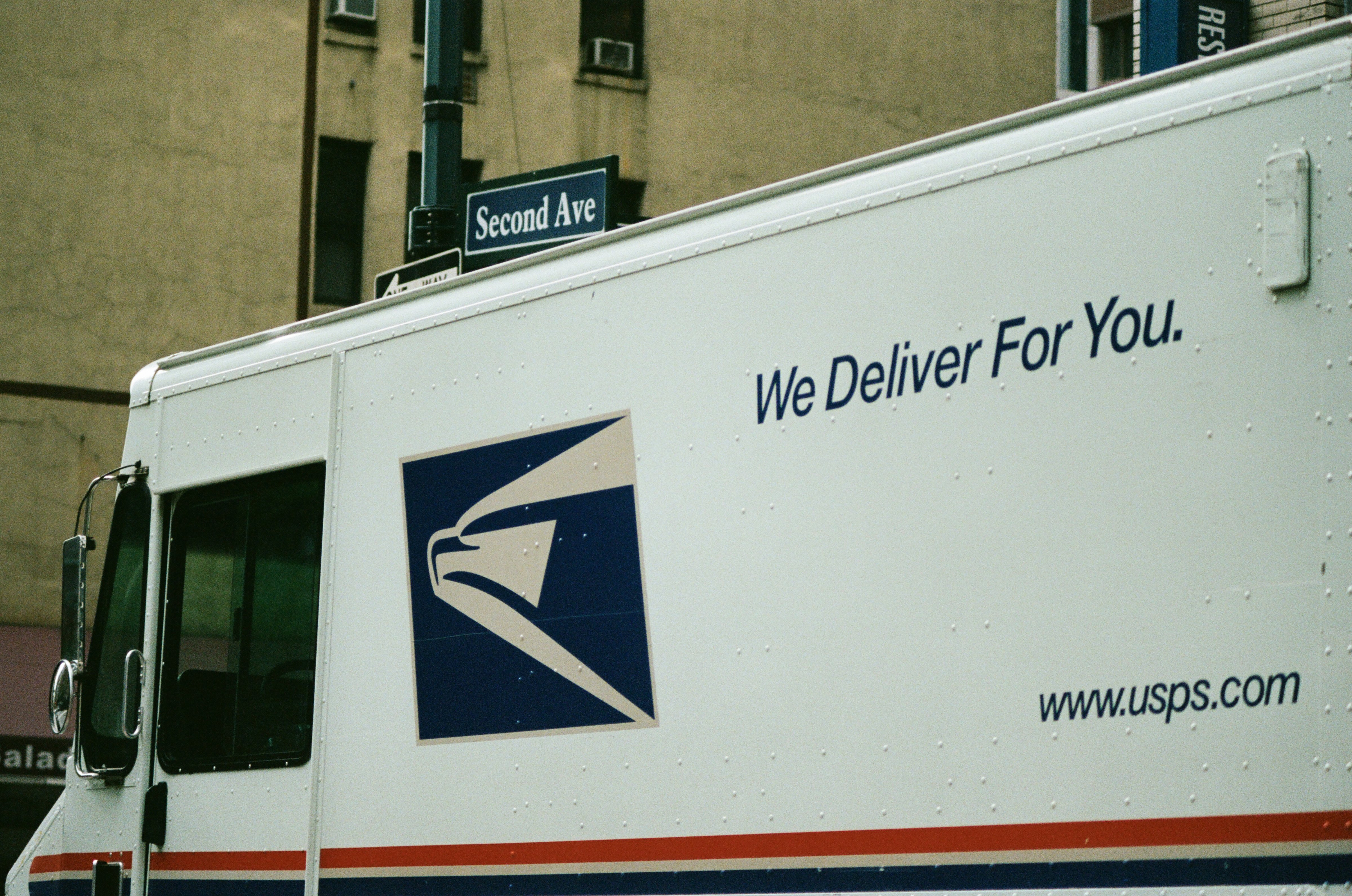 Close-up of logo on a United States Postal Service (USPS) mail truck with tagline reading 'We Deliver For You' driving down 2nd Avenue in Manhattan, New York City, New York, September 15, 2017. (Photo by Smith Collection—Gado/Getty Images)