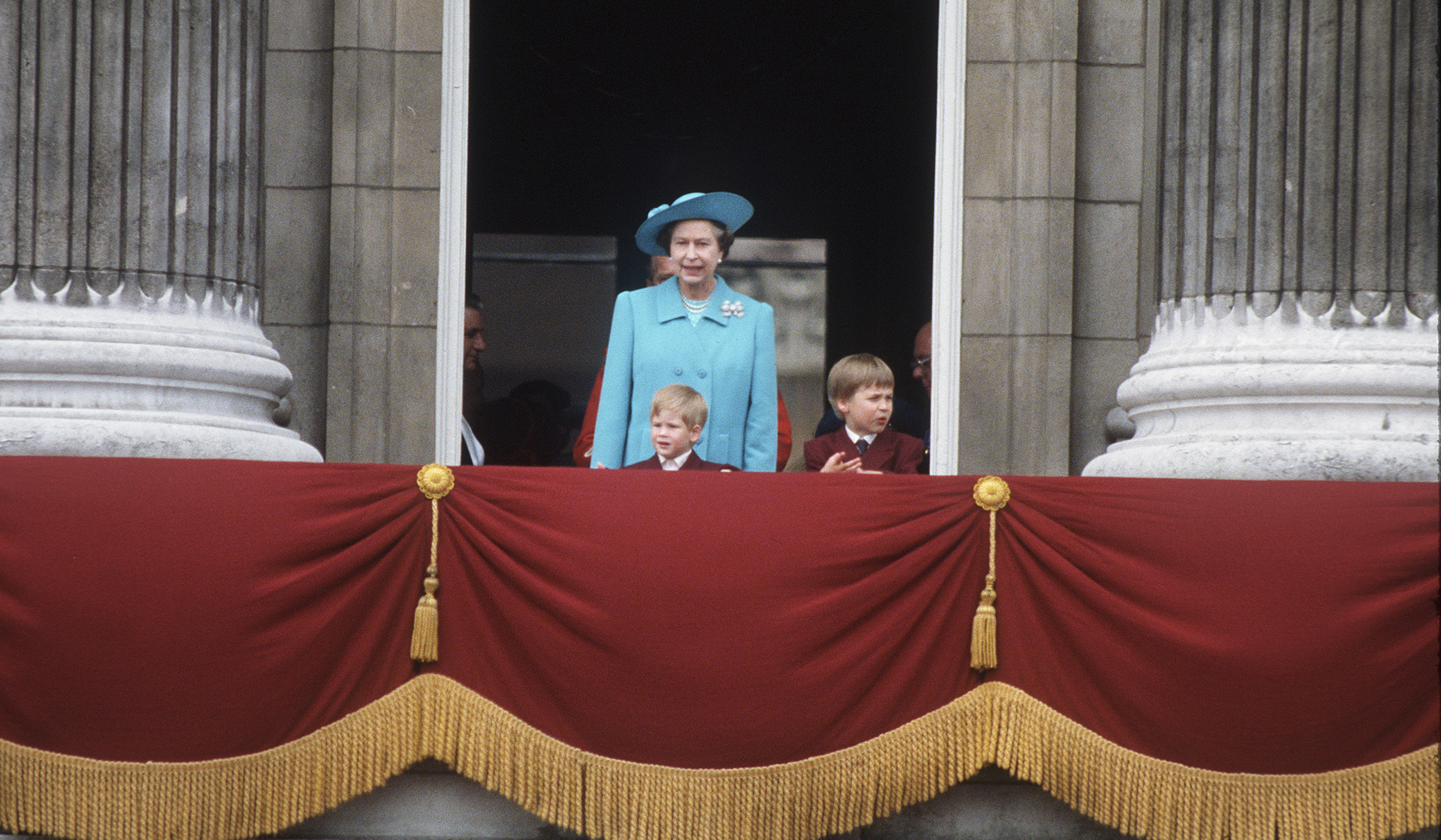 Queen Elizabeth II with the young Prince William and Prince Harry on the balcony of Buckingham Palace after the annual Trooping of the Colour ceremony in June, 1988. (Anwar Hussein—Getty Images)
