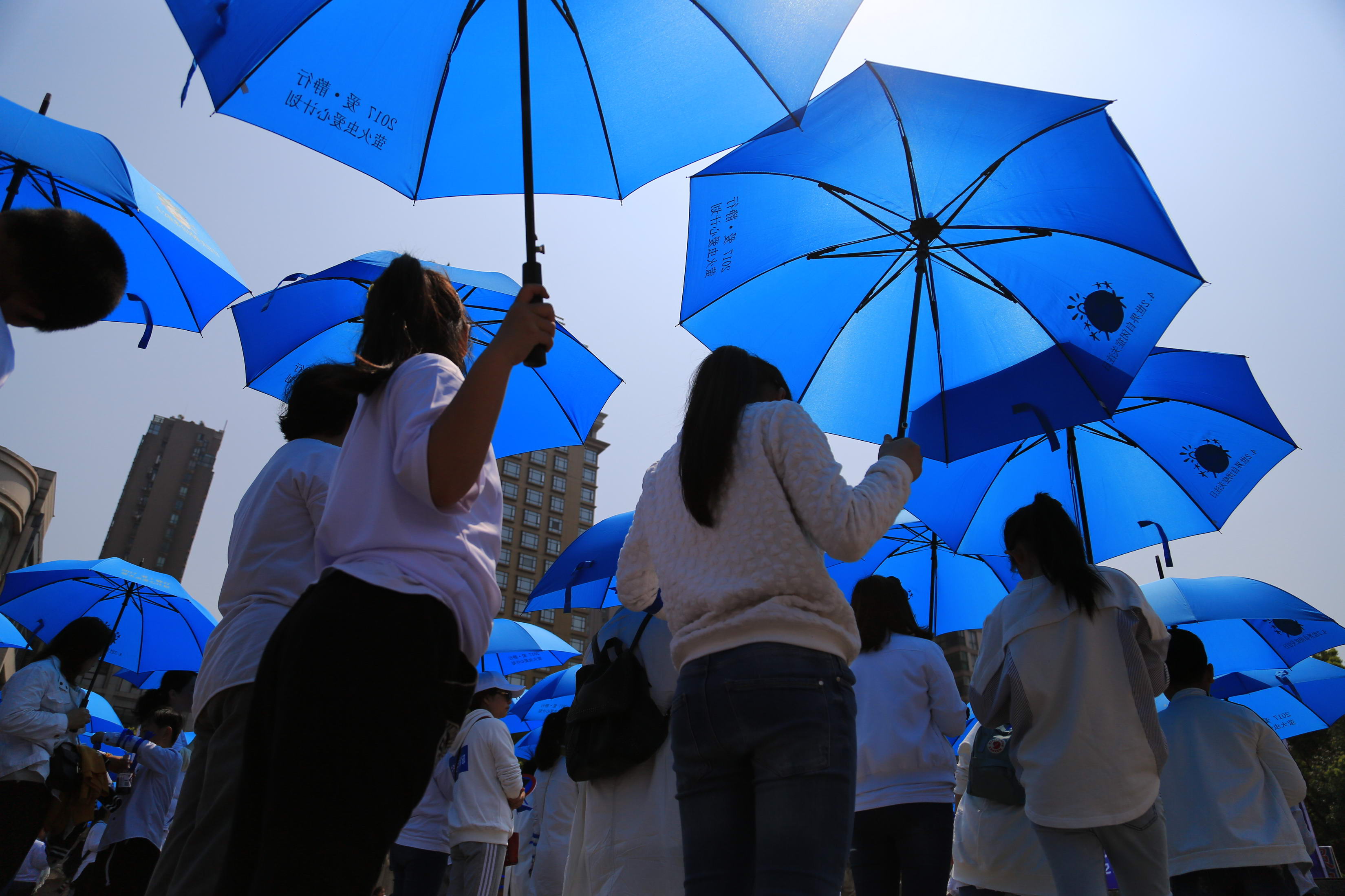 Volunteers holding blue umbrellas walk for 5 kilometers with no speaking on the World Autism Awareness Day at Pujiang County on April 2, 2017 in Jinhua, Zhejiang Province of China. (VCG—VCG via Getty Images)