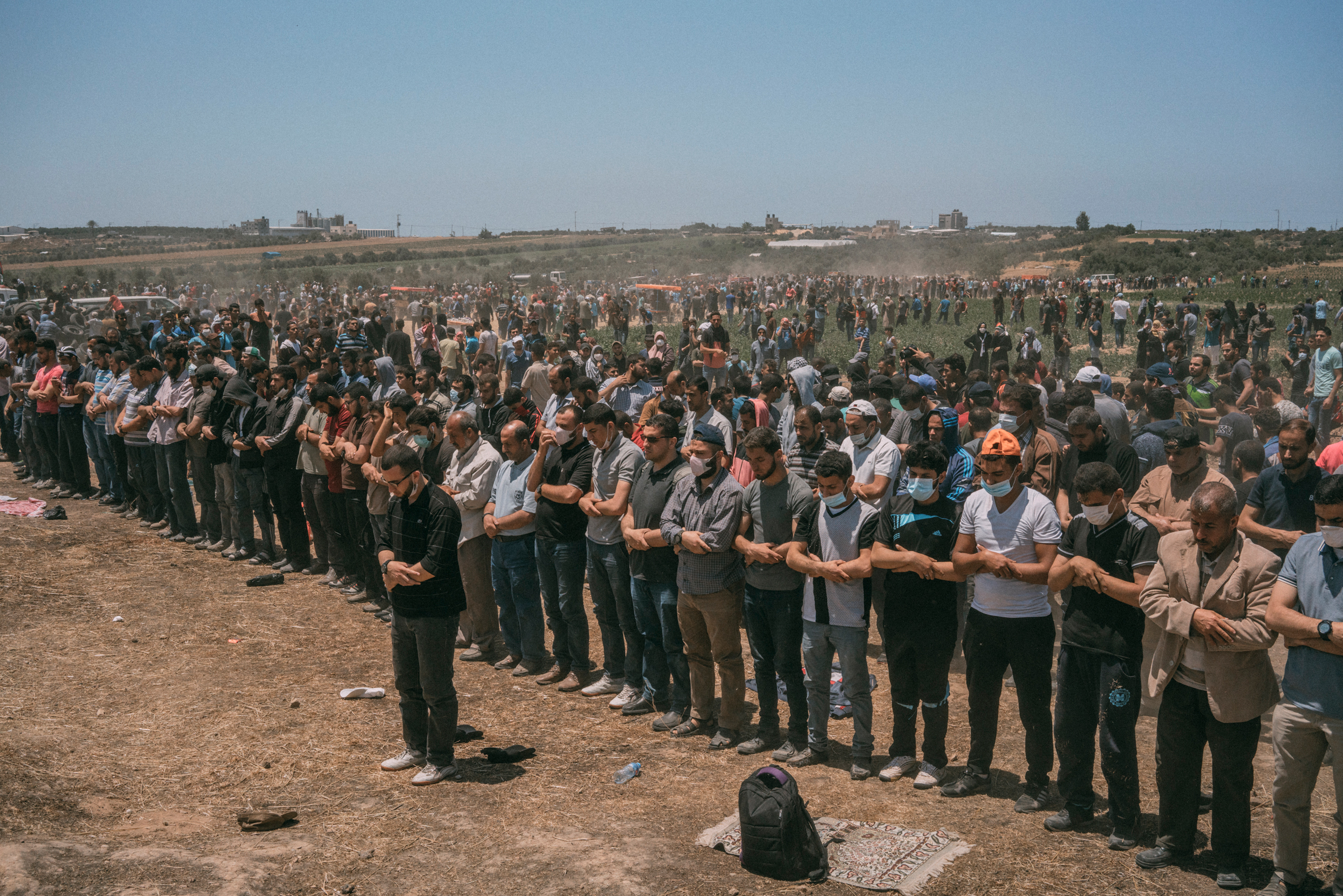 Palestinian men pray along the Gaza-Israel border. (Emanuele Satolli for TIME)
